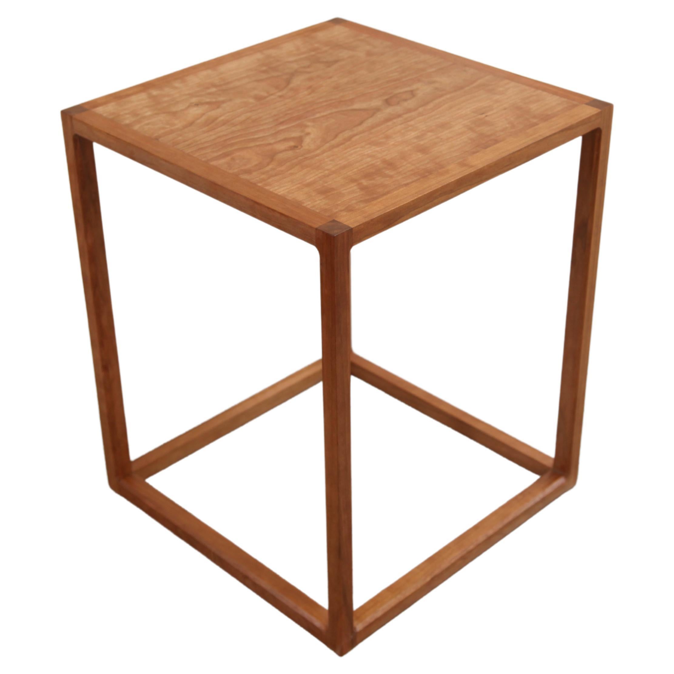 Cette table d'appoint en cerisier inspirée de Donald Judd a été conçue pour un client qui souhaitait une forme épurée et n'avait pas besoin d'un tiroir près de son lit. Il fait référence aux formes géométriques épurées de Donald Judd, mais incorpore