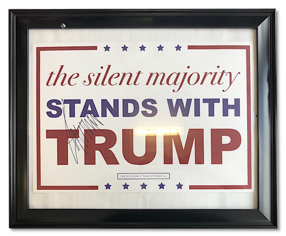A large Donald Trump autograph on a framed campaign poster. 
The poster features one of Trump's most well-known slogans: 
