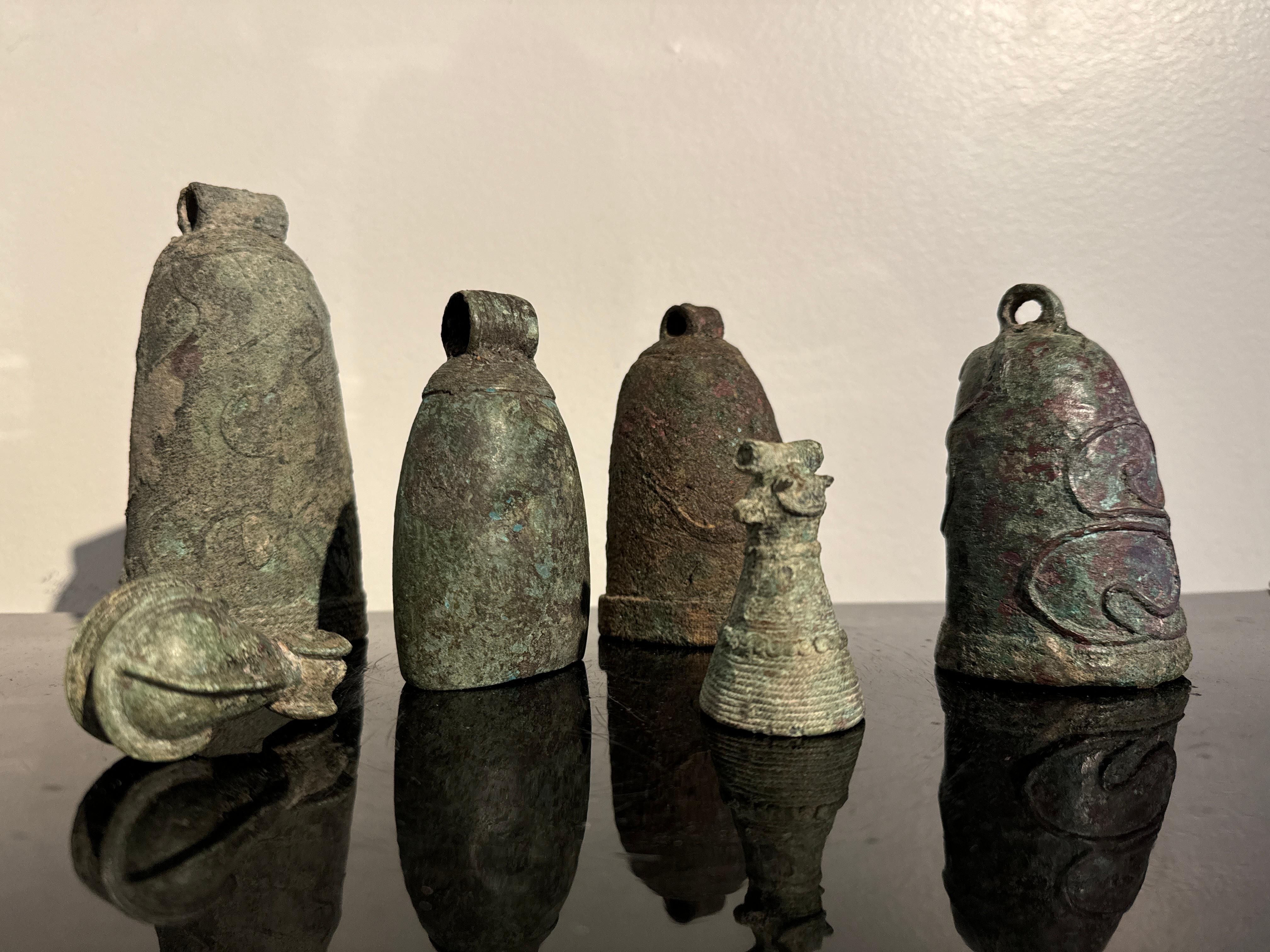 A highly decorative group of six Dong Son Culture cast bronze bells, circa 3rd to 1st century BCE, modern day Vietnam. 

The bells of various sizes, shapes, and designs. All with heavy and attractive patinas. Most with cast relief decorations to the