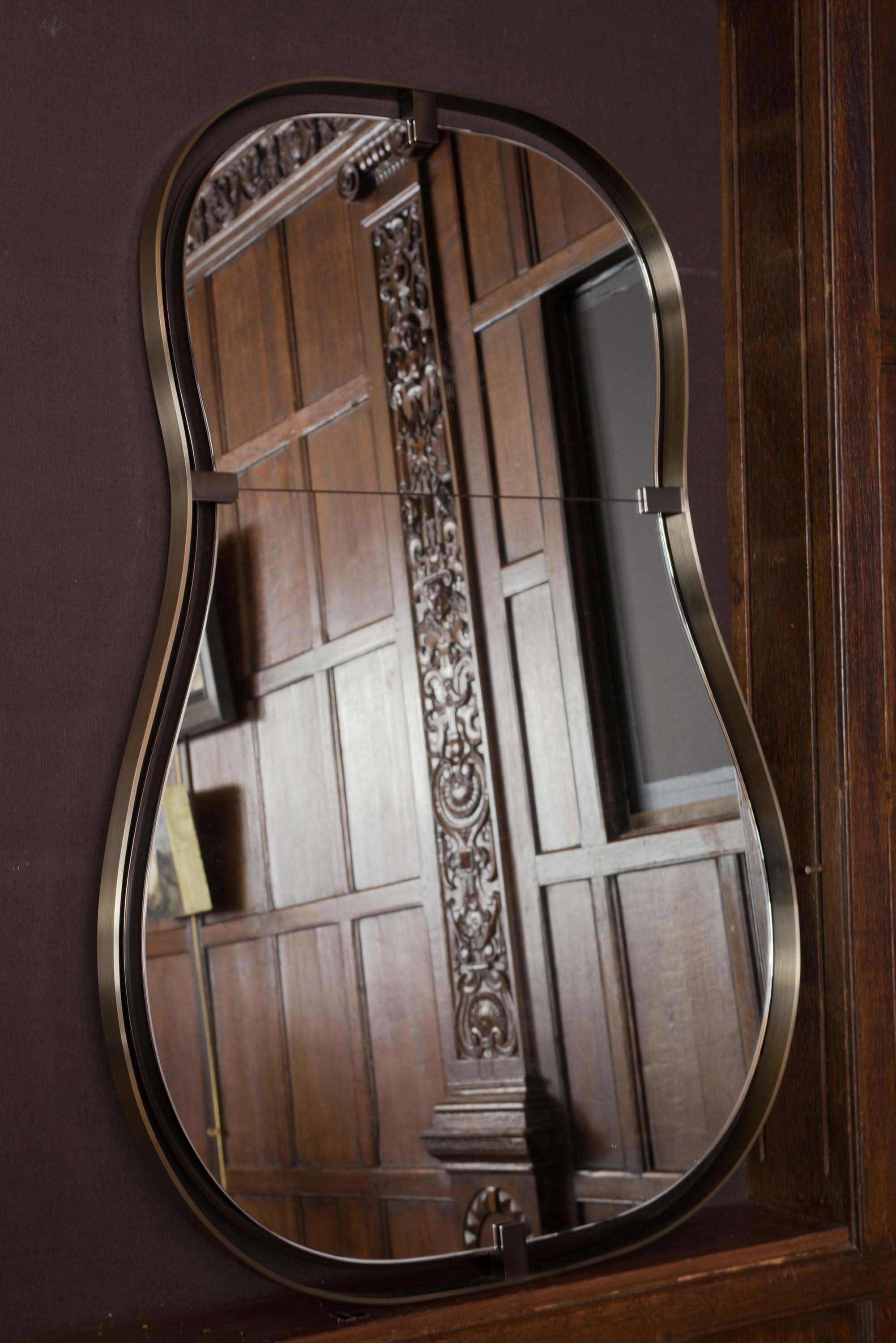 This imposing mirror is clearly feminine in shape, but offers a masculine counterpart in its metalwork. Fluid and graceful, but also stately, the Anjou Mirror adds depth to any space. Wall mirror with a metal frame. Mirror and stainless steel frame