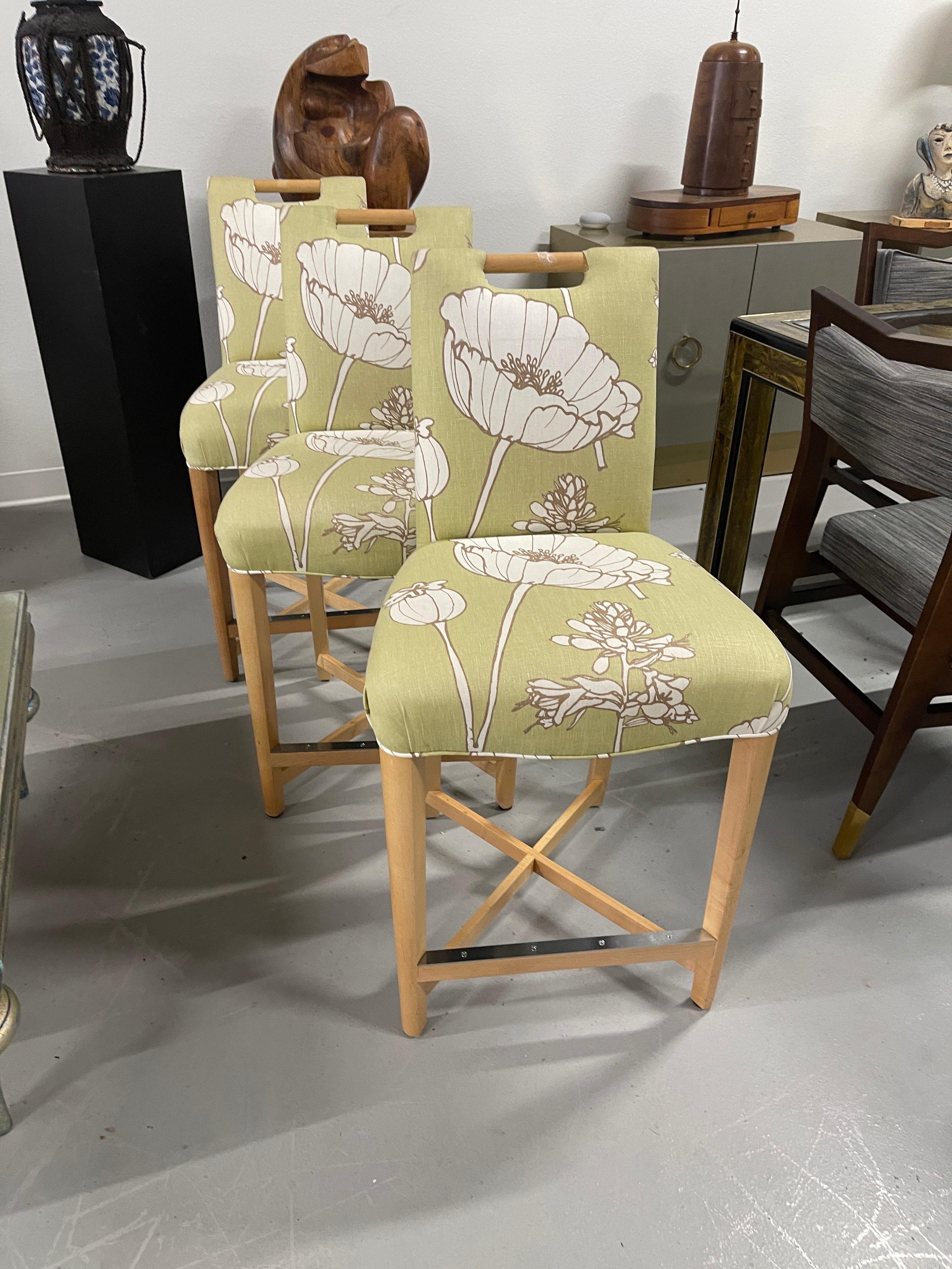 Set of three Donghia Barstools, with a pretty floral pattern. I believe the hardwood frame to be Maple. The stools have a metal reinforced piece on the foot rest. They are in good vintage condition, although there is some slight fraying at the top