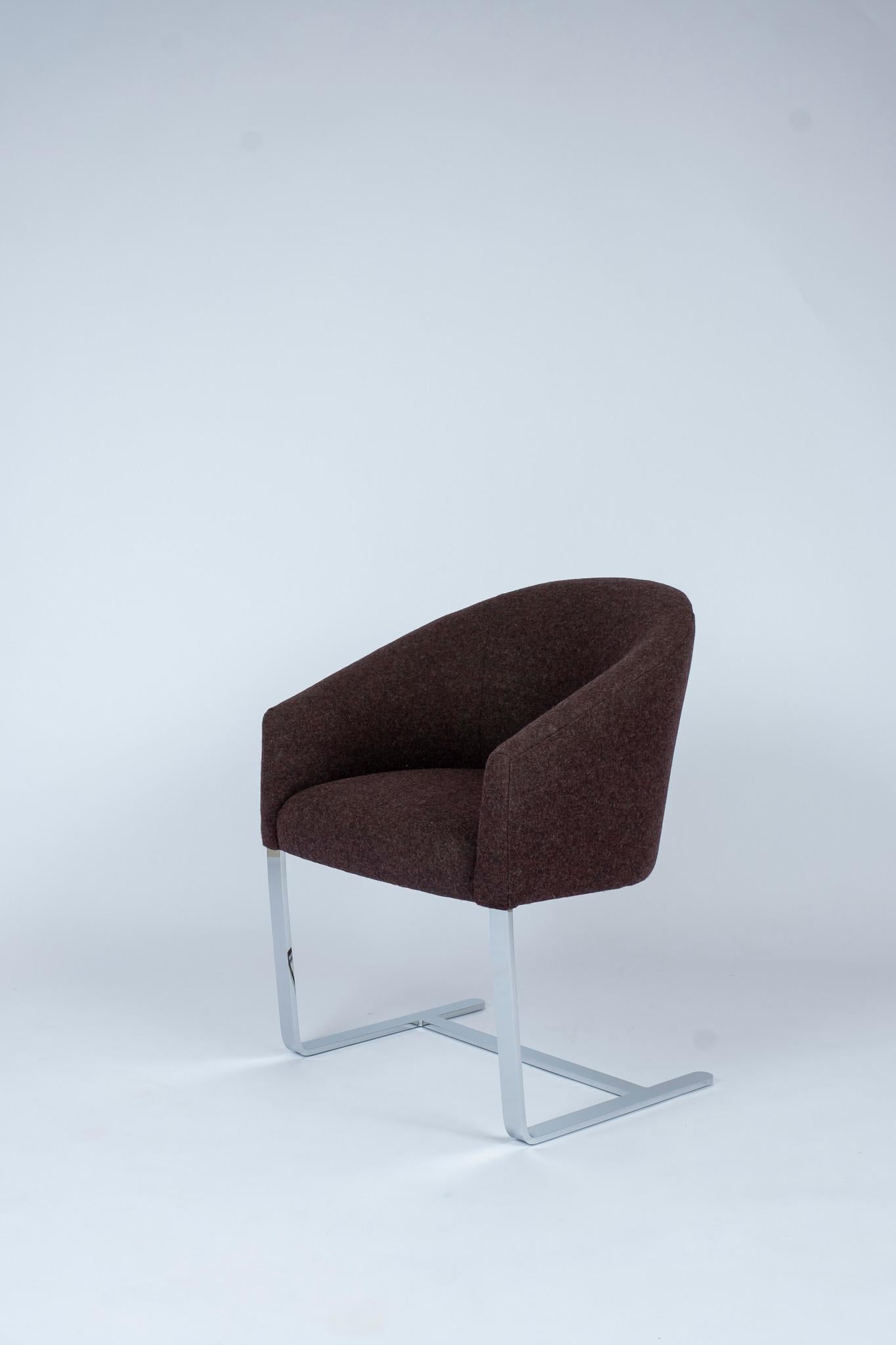 Claret wine felt wool style upholstered chair with tub-shaped tight back and seat cantilevered on a polished chromed steel base.
