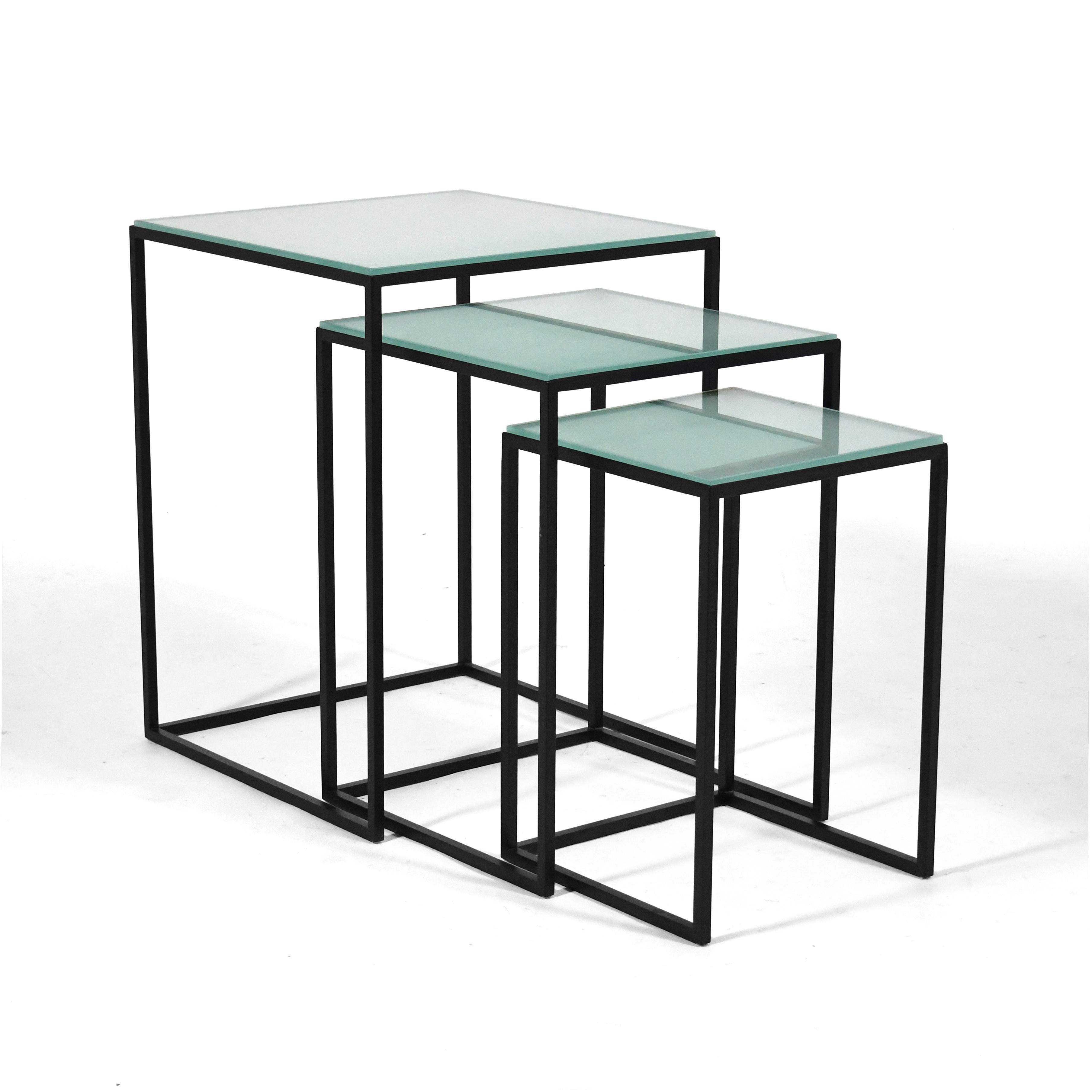 This set of nesting tables by Donghia have a striking minimalist design with frames of iron with a black finish that support tops of frosted glass.

24