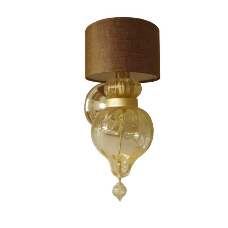 Fluid grace abounds in the handblown Murano Torre sconce. Wall sconce in handblown Murano glass. Clear glass with gold leaf inclusions, hand silvered glass, and brass hardware.

- Back plate dimensions: 4.75