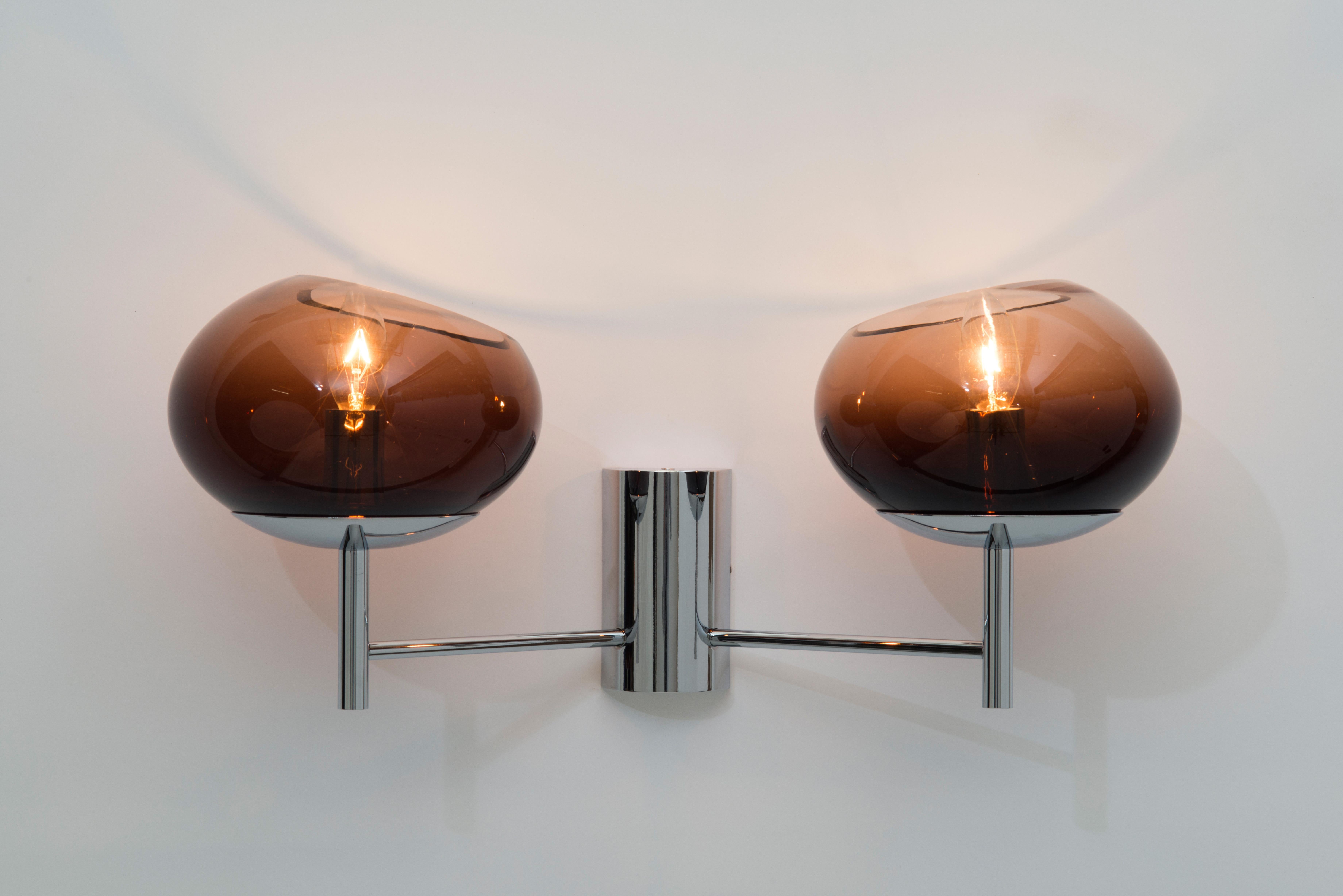 This handblown glass sconce epitomizes the 1970s chic lifestyle and look that Angelo Donghia was known for and that remains part of the Donghia aesthetic and DNA. This sconce boasts a graduation in density of color creating an ombre effect. The