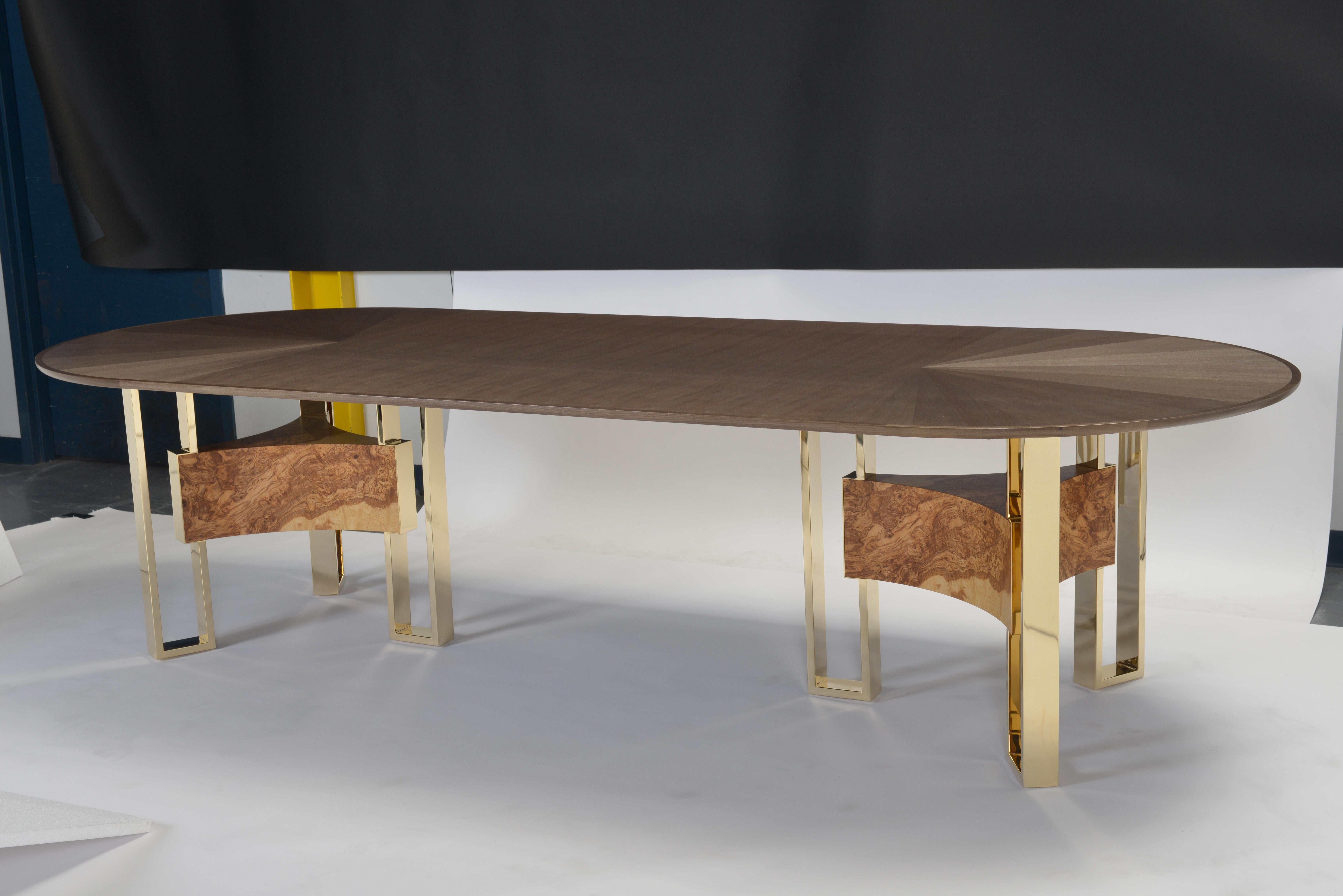 Obround dining table veneered in quartered walnut, bookmatched in a starburst pattern at each end with a slip matched centre field with quarter sawn walnut solid bands in an open grain finish in a medium sheen. Choose between polished gold-plated or