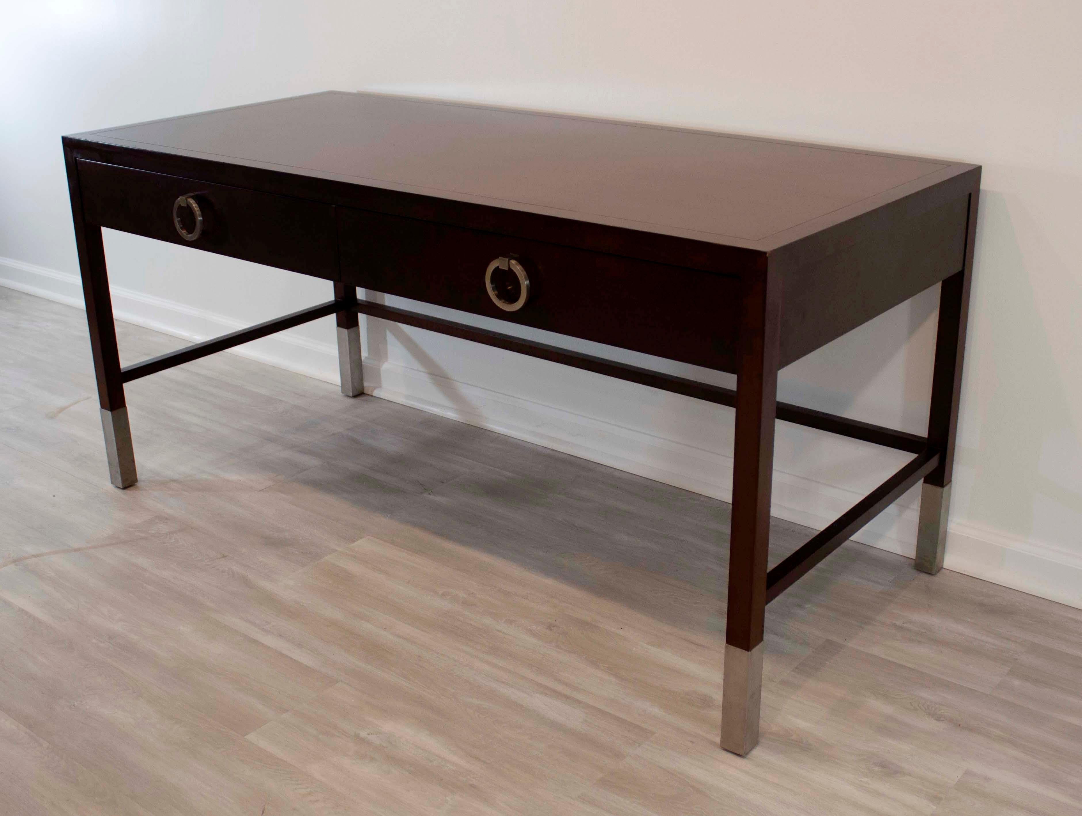 This tailored and sophisticated, this Parsons style desk designed by Angelo Donghia and includes two generous sized dovetailed drawers detailed with satin chrome round pulls and matching ferrules on each leg. The desk is in very good condition with