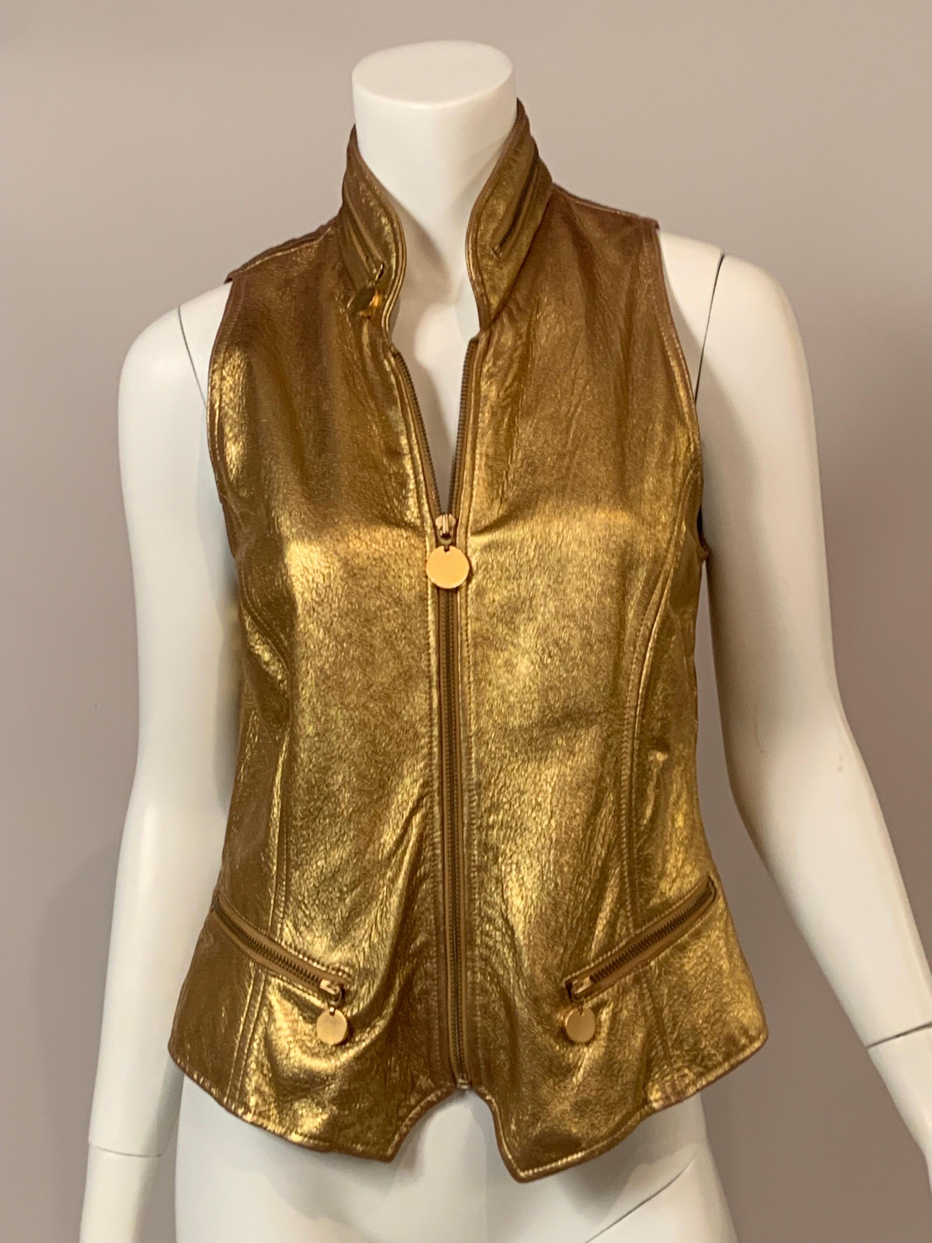 Donna Karan designed this glamorous 1980's gold leather vest with a center front zipper, two zip pockets and a zipper on the collar. They are all finished with a round gold zipper pull. The leather is soft as butter, and the vest is fully lined. It