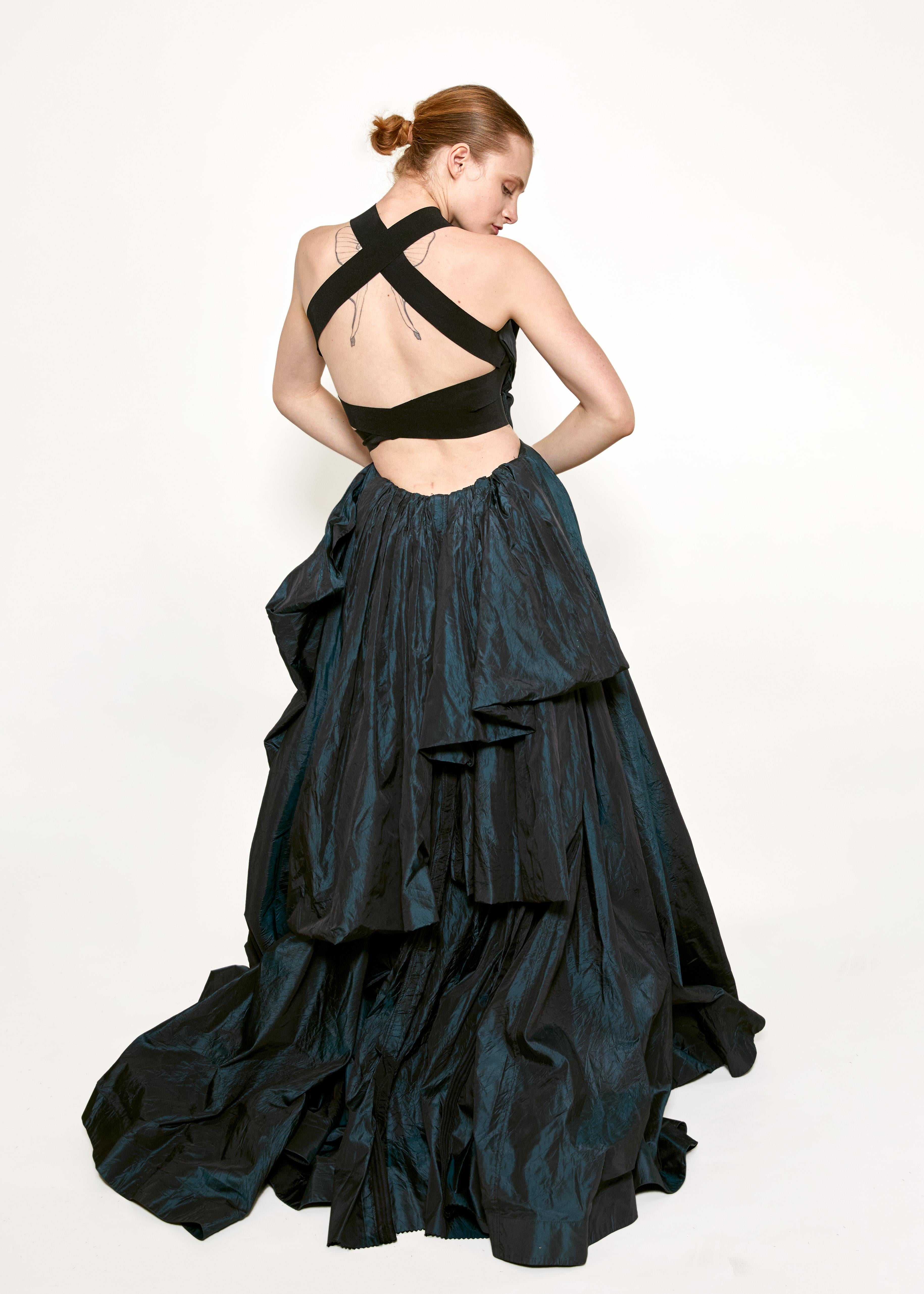 Be bold with the Donna Karan 2006 Iridescent Blue Taffeta Gown. Made with magical iridescent taffeta, this gown creates a dark fairytale illusion in black/blue. Embrace the whimsical and take risks with this breathtaking piece.
Made in the