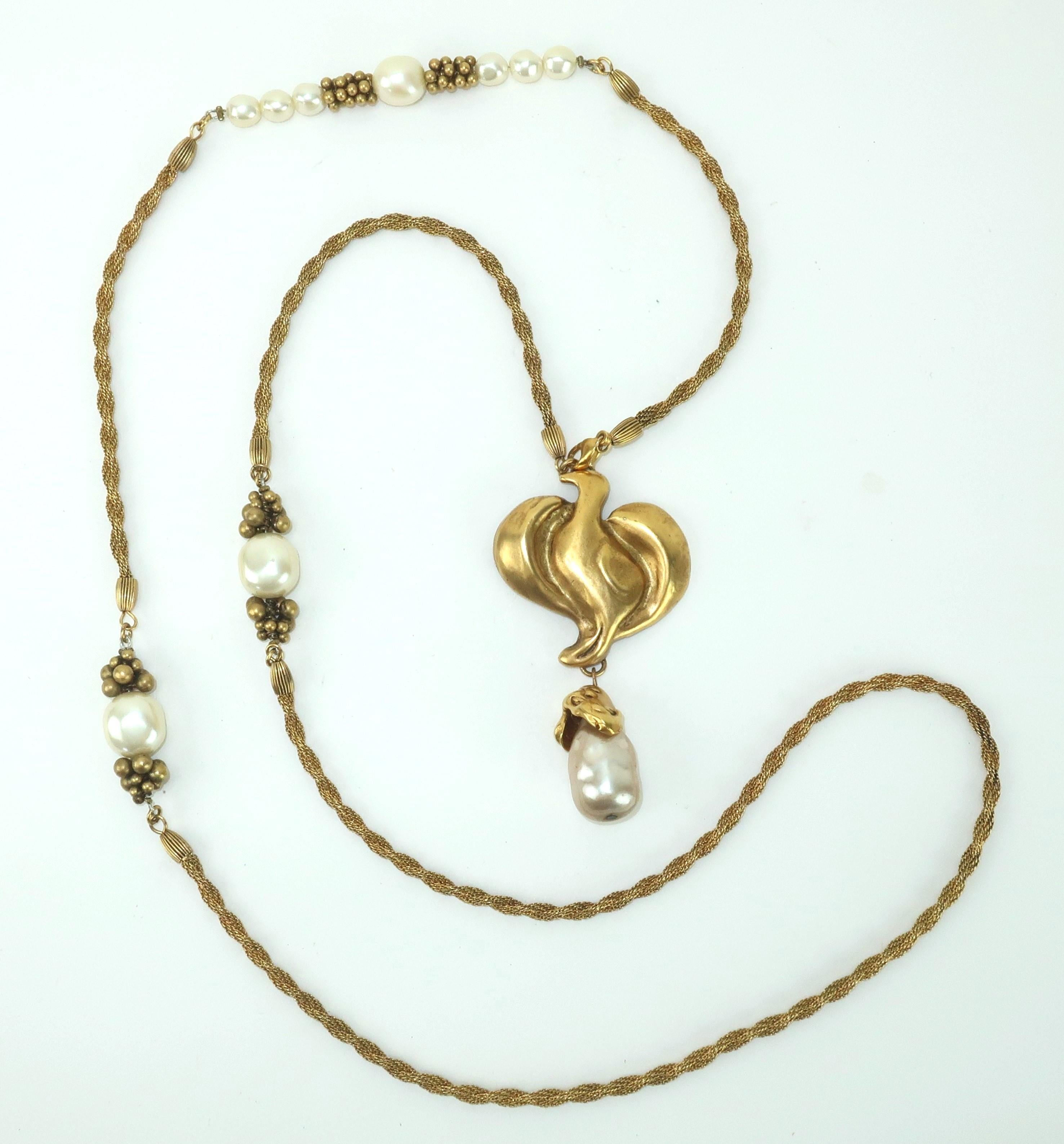 Late 20th Century opera length gold tone rope necklace with an abstract bird pendant and faux baroque pearl accents.  The necklace is beautifully made with quality details including the cluster beading around the pearls and fluted fittings