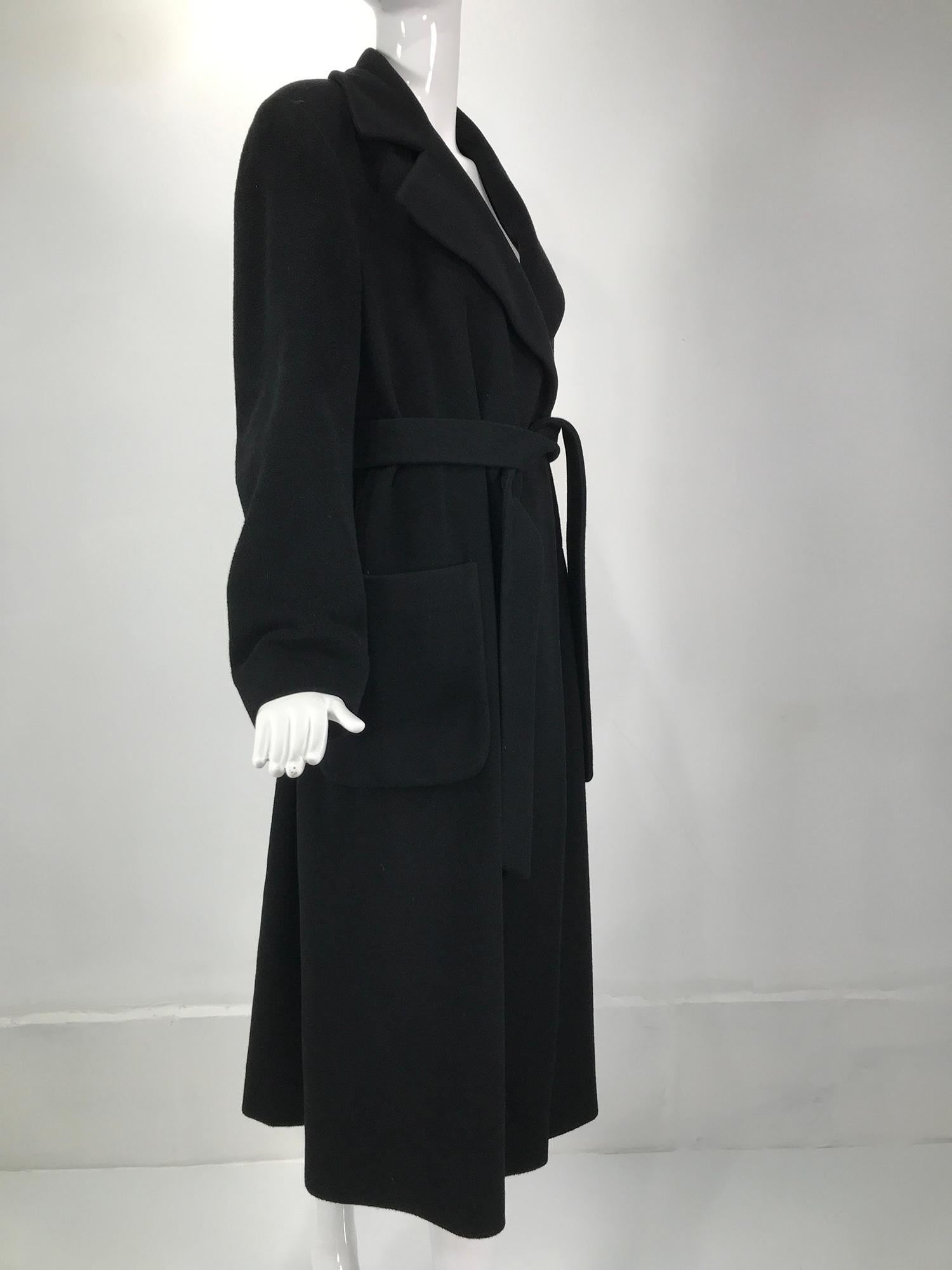 Donna Karan black cashmere wrap coat size 10. Sleek and eternally stylish the wrap coat can go anywhere. Belted coat with deep lapels, long sleeves and hidden button closure at the waist, the coat closes with it's own self cashmere belt. Fully lined