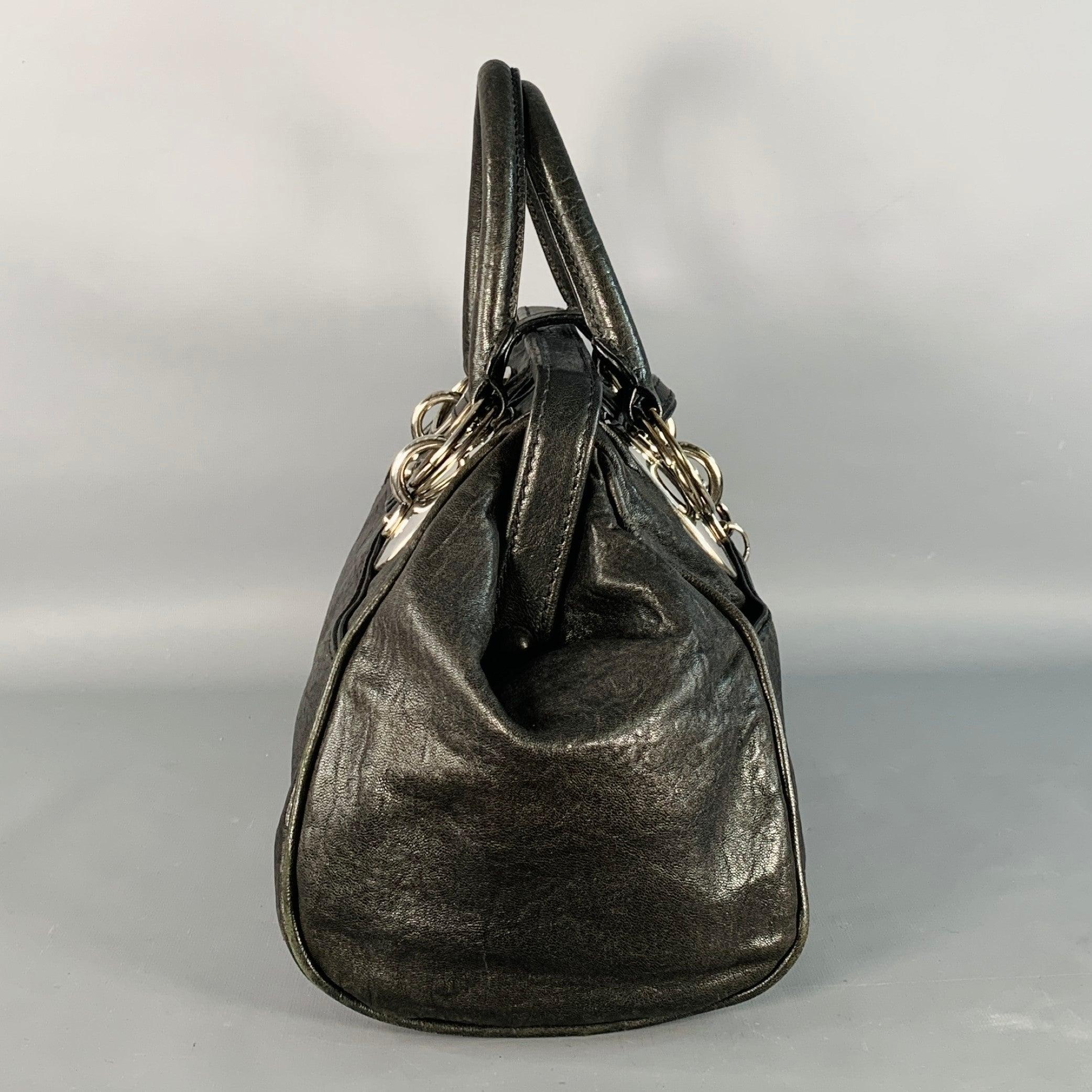 Sacoche de médecin DONNA KARAN
en cuir noir, avec des accessoires en métal argenté, des poignées supérieures et une fermeture par boutons-pression.Très bon état d'occasion. Signes d'usure sur le matériel. 

Mesures : 
  Longueur : 15.75 pouces