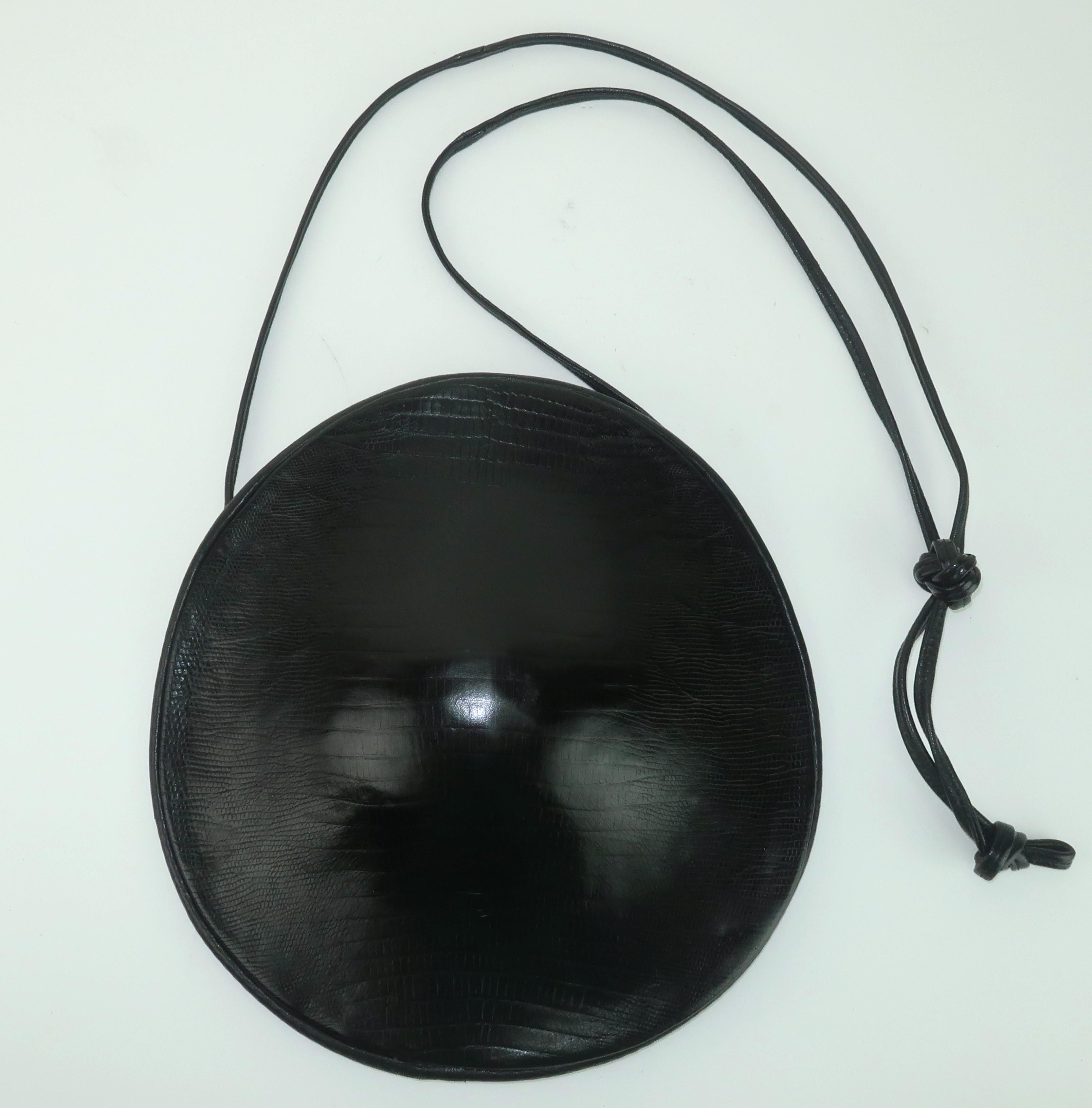 1980’s Donna Karan New York black leather handbag embossed with a lizard skin design.  The unusual sculptural silhouette is reminiscent of a turtle shell or shield.  The back is in a buttery soft leather with an open entry and drawstring closure. 