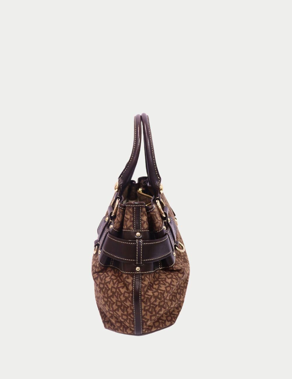 DKNY Brown Monogram Satchel with Dark Chocolate Leather Straps & Gold Hardware

This DKNY monogram satchel is the perfect blend of bold structure and timeless sophistication. Crafted in brown logo canvas, it features double rolled handles, dark