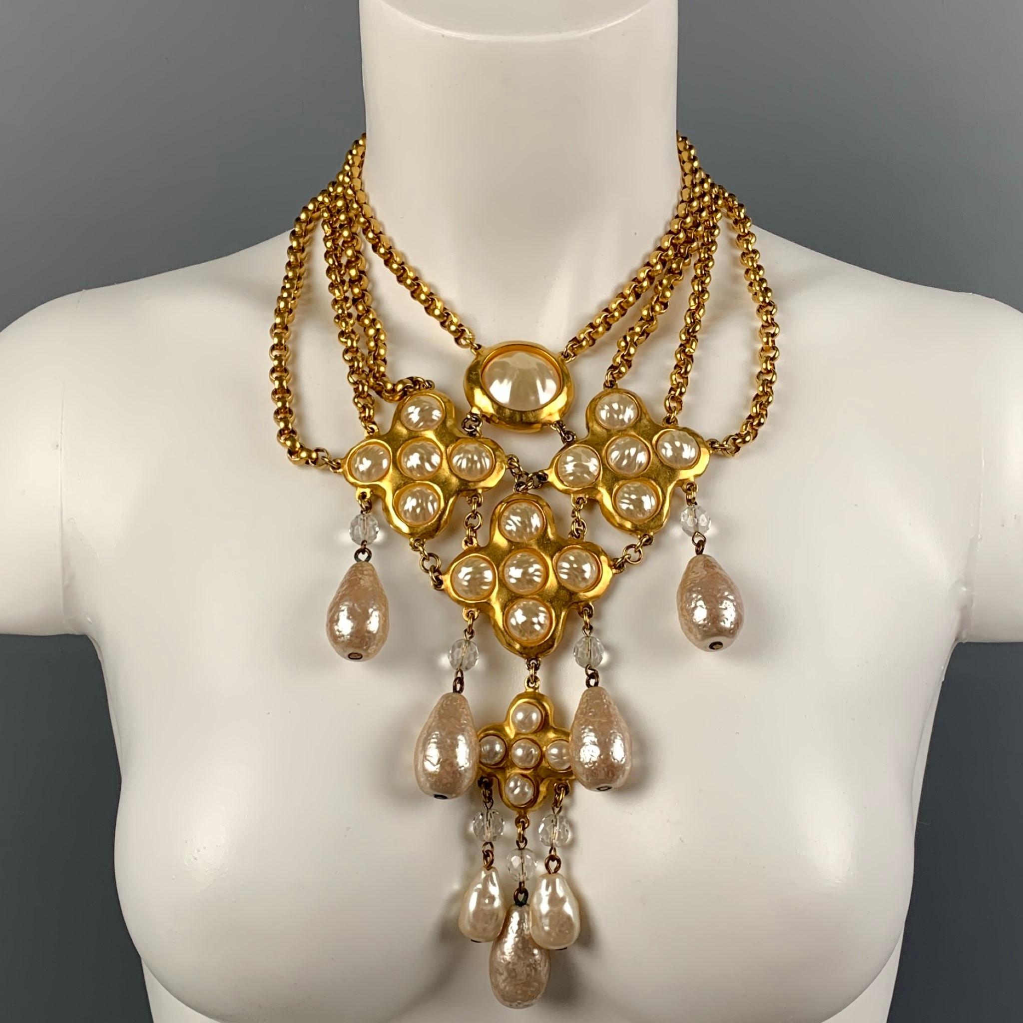 DONNA KARAN necklace comes in a gold tone metal featuring a layered chain link style, faux pearls, large pendant design, and a clasp closure. 

Good Pre-Owned Condition.

Measurements:

Length: 16 in.
Pendant Length: 4.5 in.
Pendant Height: 7 in. 