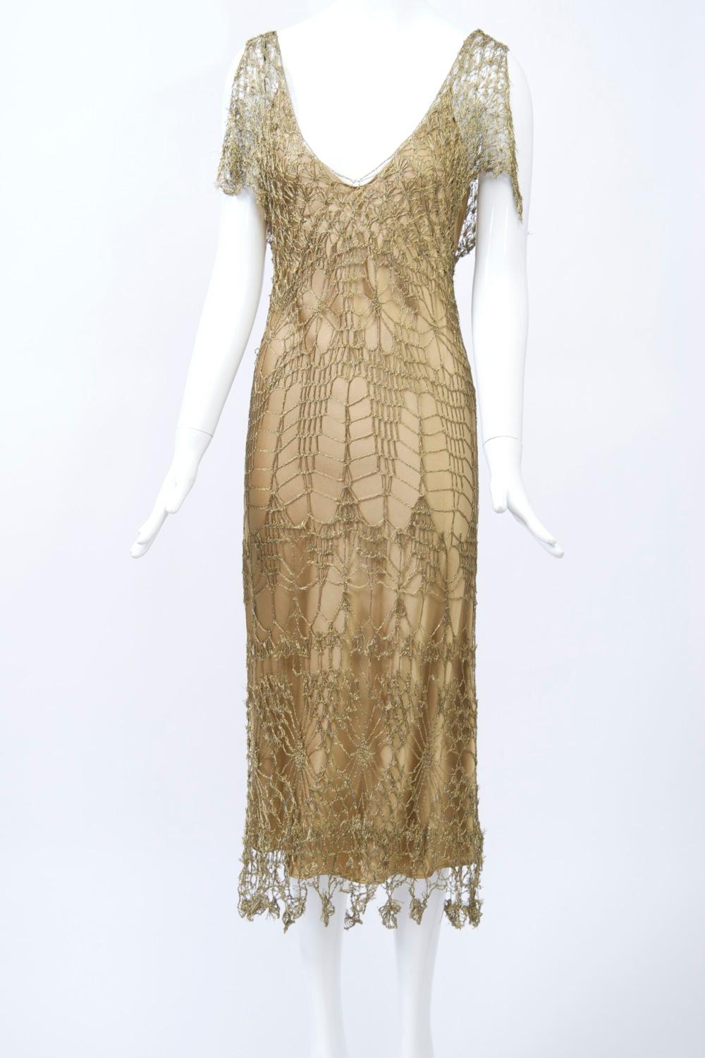Donna Karan metallic gold crochet lace dress with a complementary silk charmeuse slip dress underneath. The crochet dress skims the body and features a deep V neckline front and back, slit cap sleeves, and handkerchief points at the hem. Both pieces