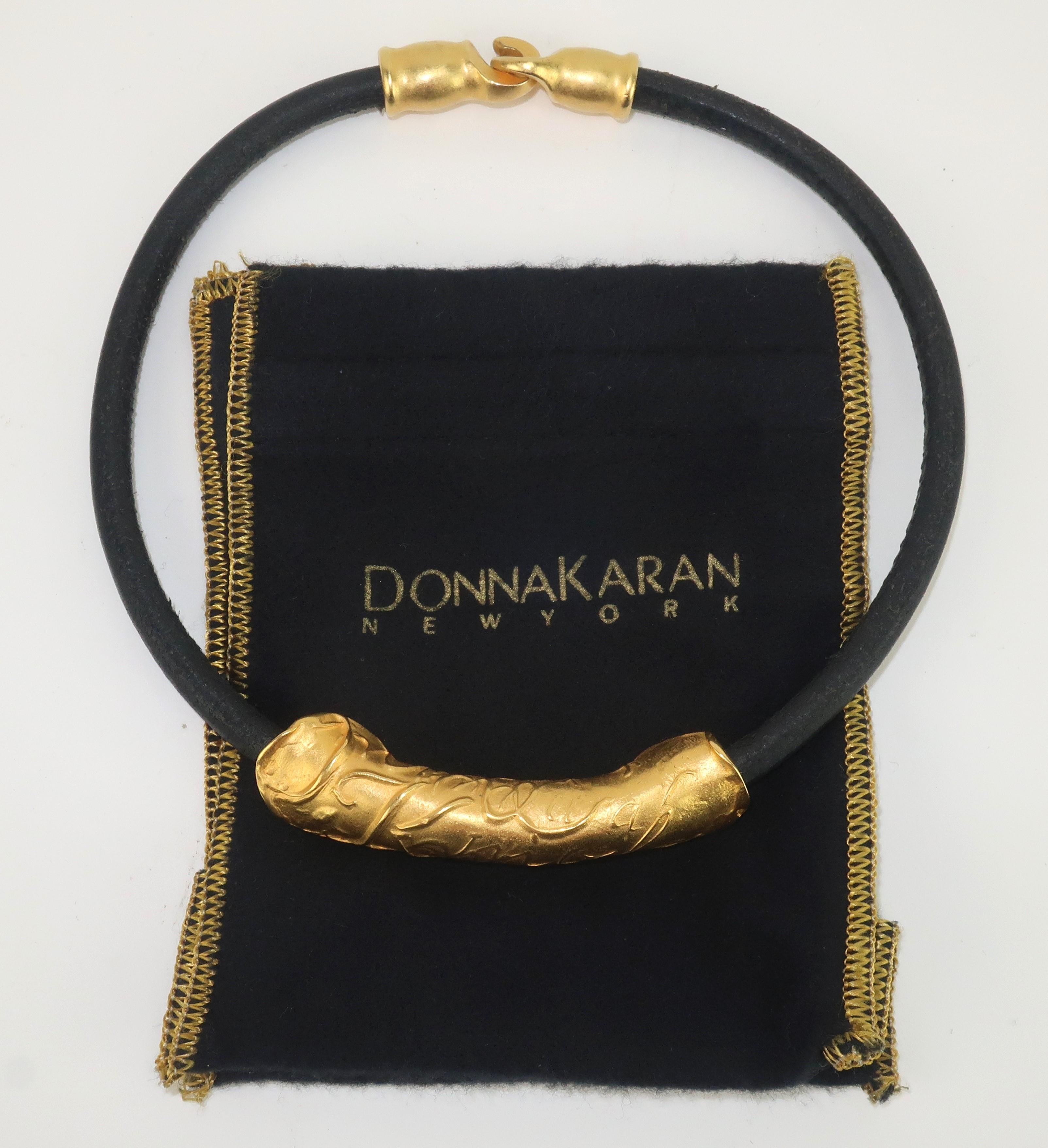 Donna Karan once described her fashion label as 'modern clothes for modern people' and this simple gilt metal and leather choker necklace is the perfect accessory for a modernist look.  A close look at the gilt metal pendant reveals a scattering of