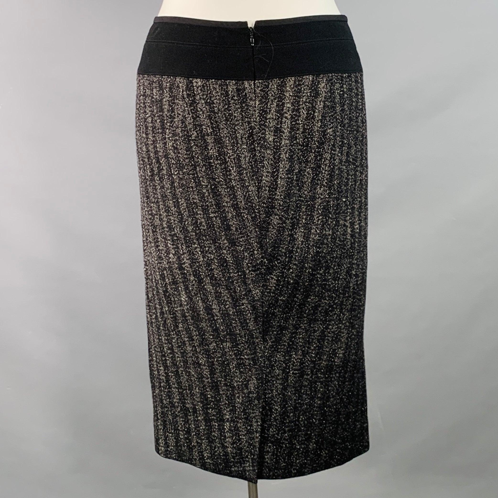 La gonna midi di Donna Karan in misto lana nera e argento è caratterizzata da uno stile a matita, un motivo a righe tono su tono e una chiusura con cerniera posteriore.Nuova con etichetta. 

Contrassegnato:   10 

Misure: 
  Vita: 33 pollici