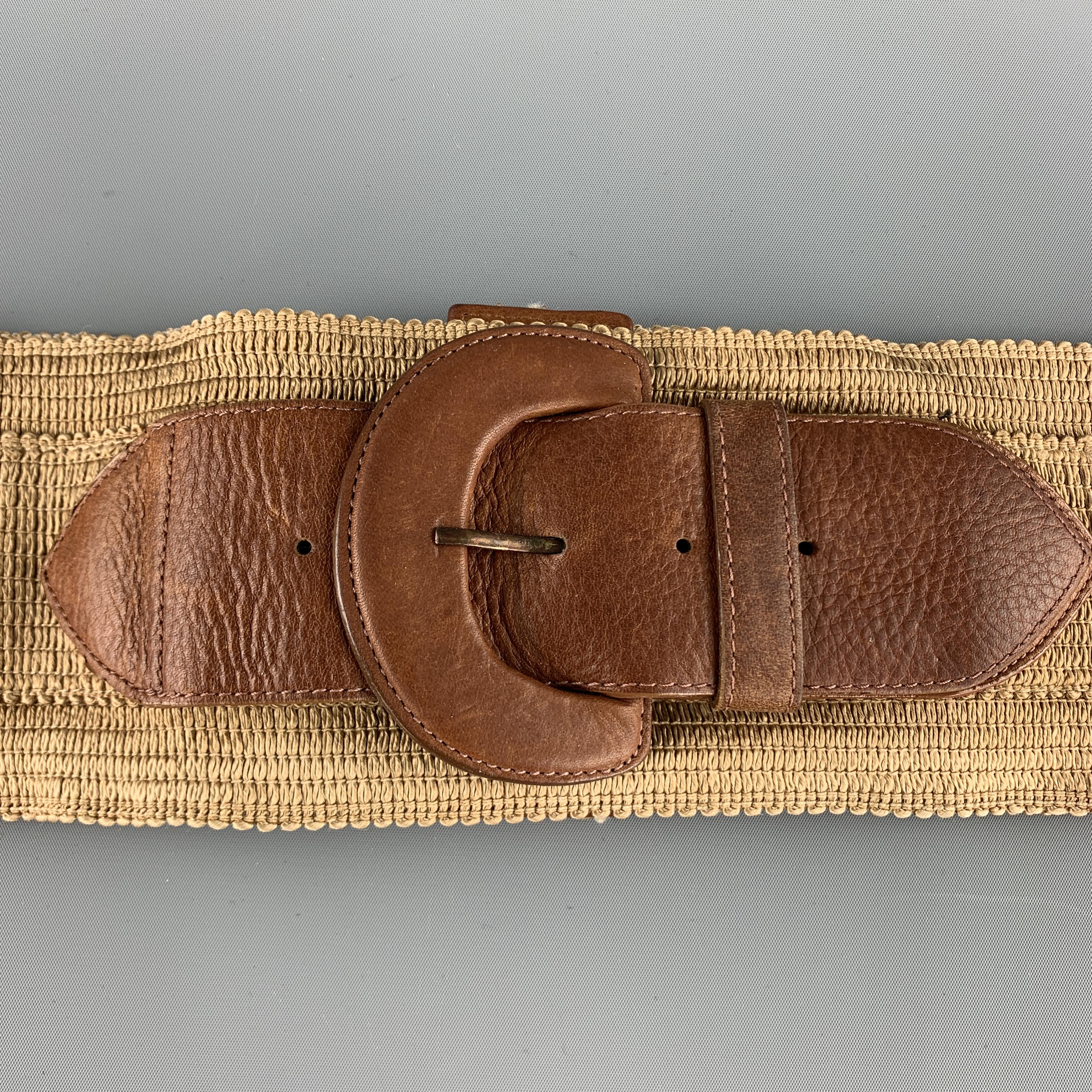 Vintage DONNA KARAN waist belt features a thick beige stretch band with a brown leather buckle embellishment and leather accented snap back closure. 
 

Very Good Pre-Owned Condition.
Marked: US 4

Length: 26 in.
Width: 4 in.
Fits: 25 in.
