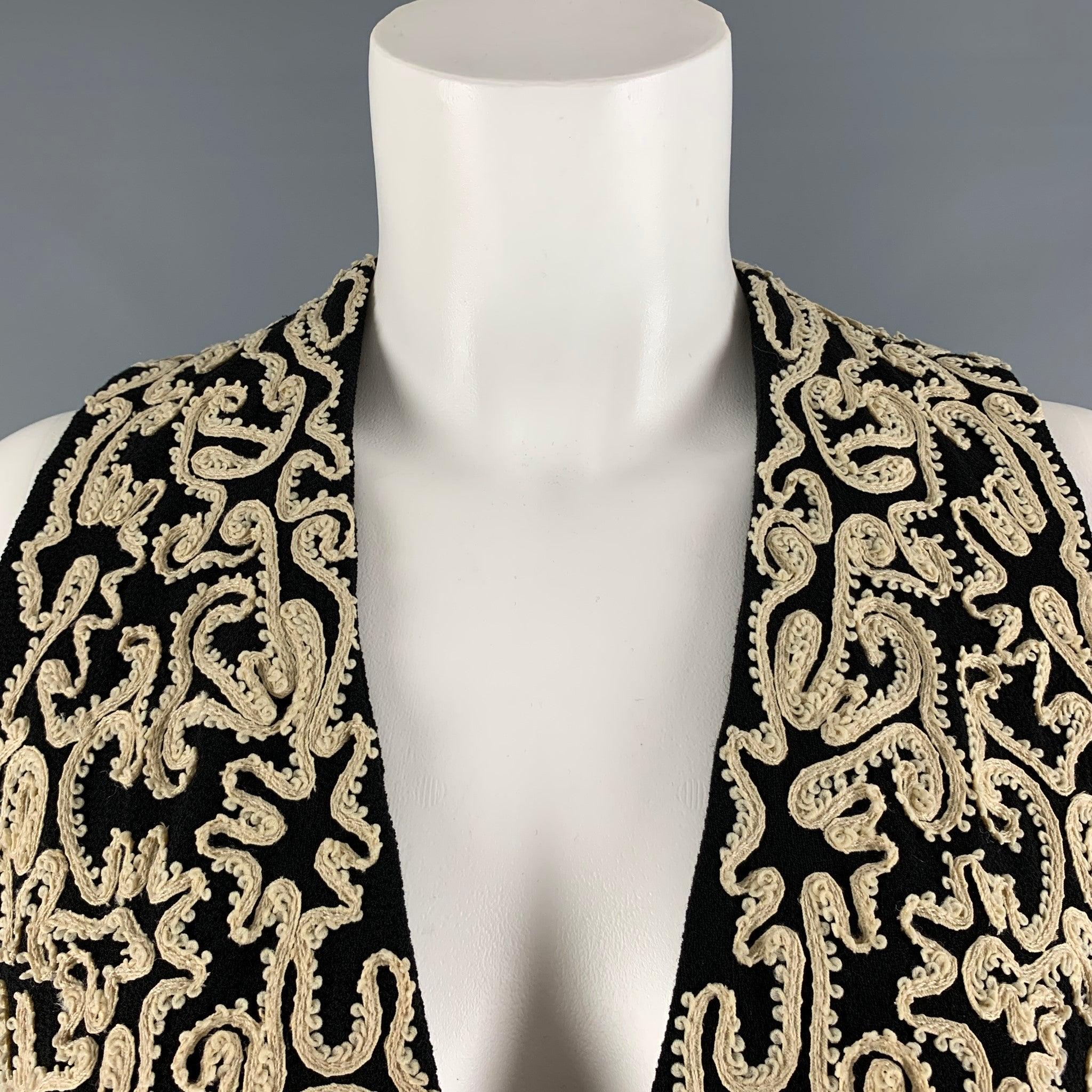DONNA KARAN vest comes in a black wool woven material featuring cream embellished ribbon details, and black rhinestones button closure. Very Good Pre-Owned Condition. Minor signs of wear. 

Marked:   6 

Measurements: 
 
Shoulder: 12 inches Bust: 34