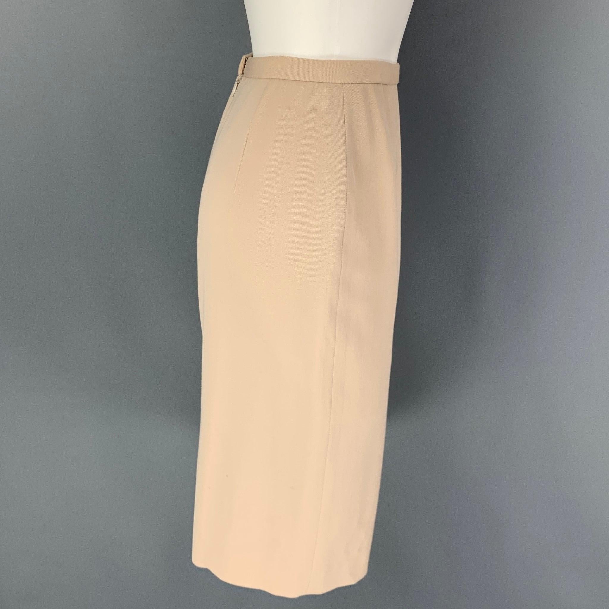 DONNA KARAN skirt comes in a beige wool with a slip liner featuring a pencil style, back slit, and a back zipper closure. Made in USA.
Very Good Pre-Owned Condition. 

Marked:   8 

Measurements: 
  Waist: 28 inches Hip: 38 inches Length: 26 inches