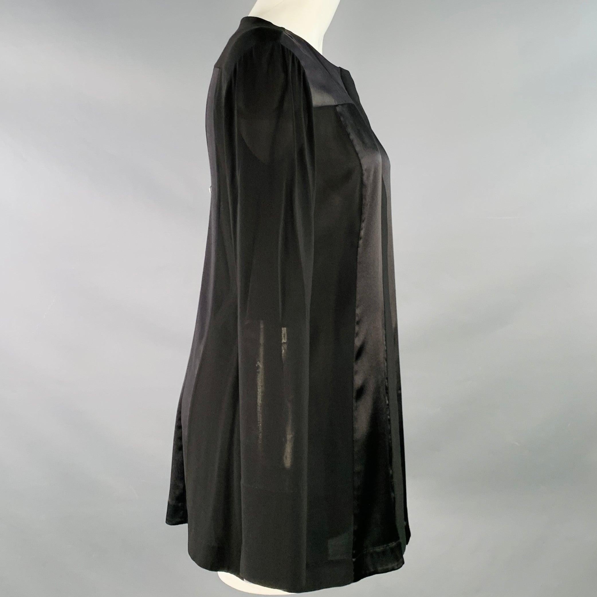 Camicetta Donna Karan
in tessuto misto viscosa elasticizzato nero, senza colletto, con pannello in raso e chiusura a bottoni nascosta con dettaglio peekaboo color crema. Molti piccoli segni di usura, così com'è. 

Contrassegnato:   8 

Misure: 
