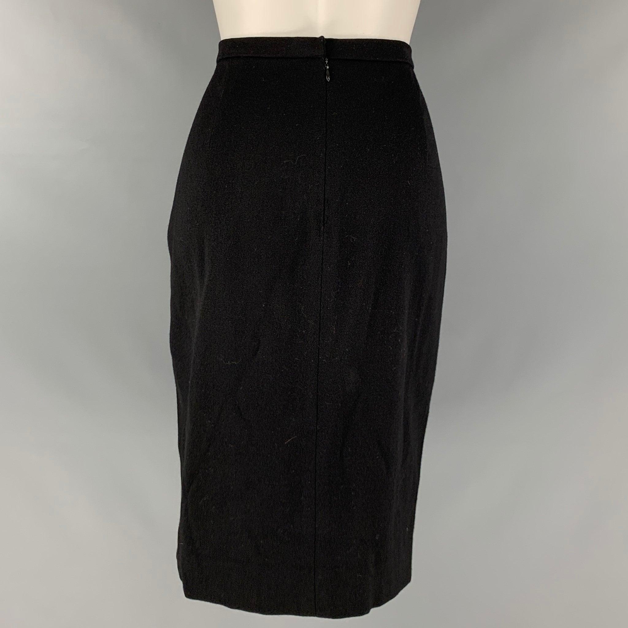 DONNA KARAN skirt comes in a black wool and lycra knit material featuring a pencil style and a back zip up closure. Made in USA.Very Good Pre-Owned Condition. Moderate signs of wear. 

Marked:   8 

Measurements: 
  Waist: 28 inches  Hip: 39 inches