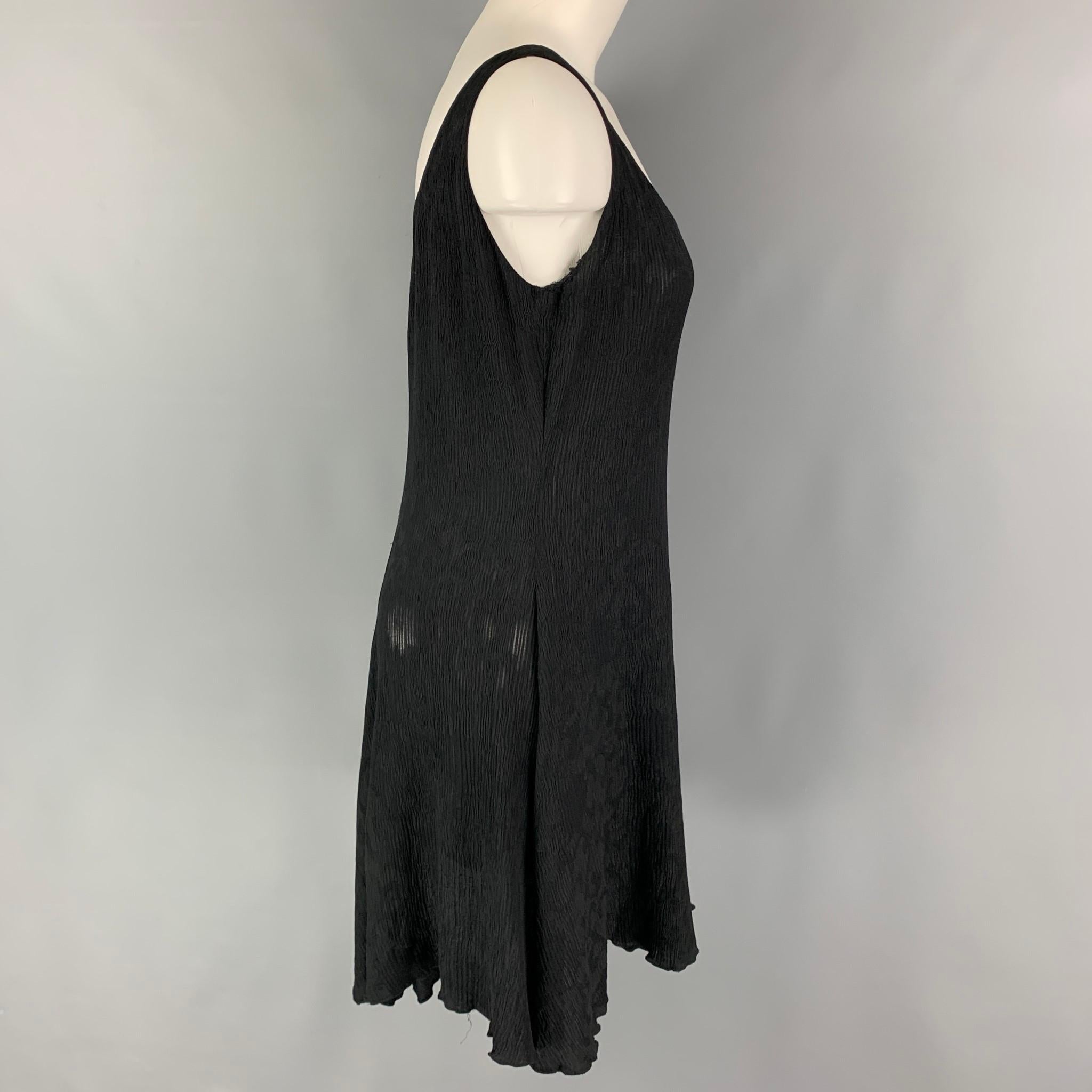 DONNA KARAN dress comes in a black jacquard material featuring a ruffled hem and a sleeveless style. 

Good Pre-Owned Condition. Fabric tag removed. Small tear at sleeve opening.
Marked: Size tag removed.

Measurements:

Bust: 34 in.
Waist: 32