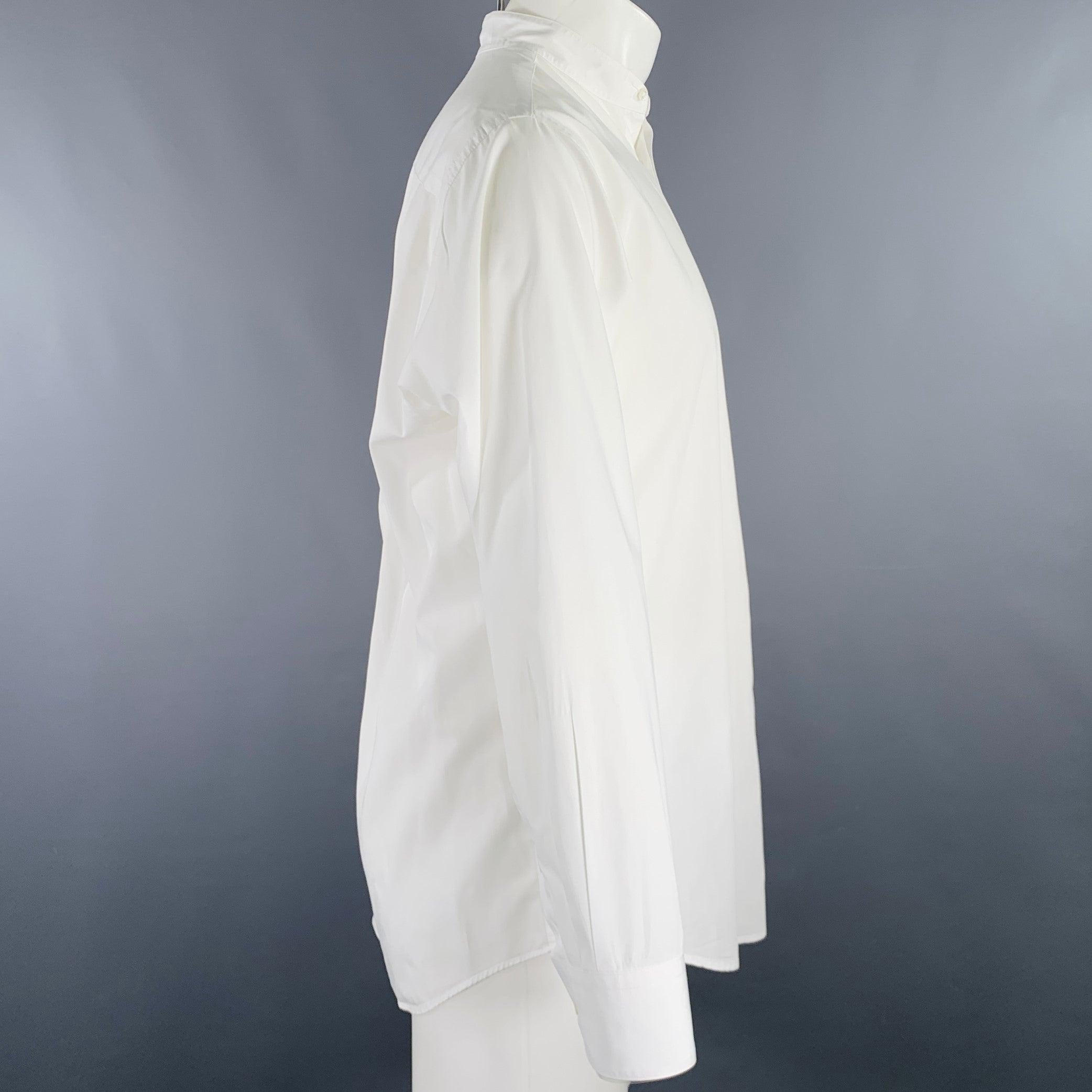 DONNA KARAN long sleeve shirt
in a white cotton woven fabric featuring a collarless style, and hidden button closure. Note: sleeves have been professionally altered and are slightly different lengths. Please double check measurements.Excellent