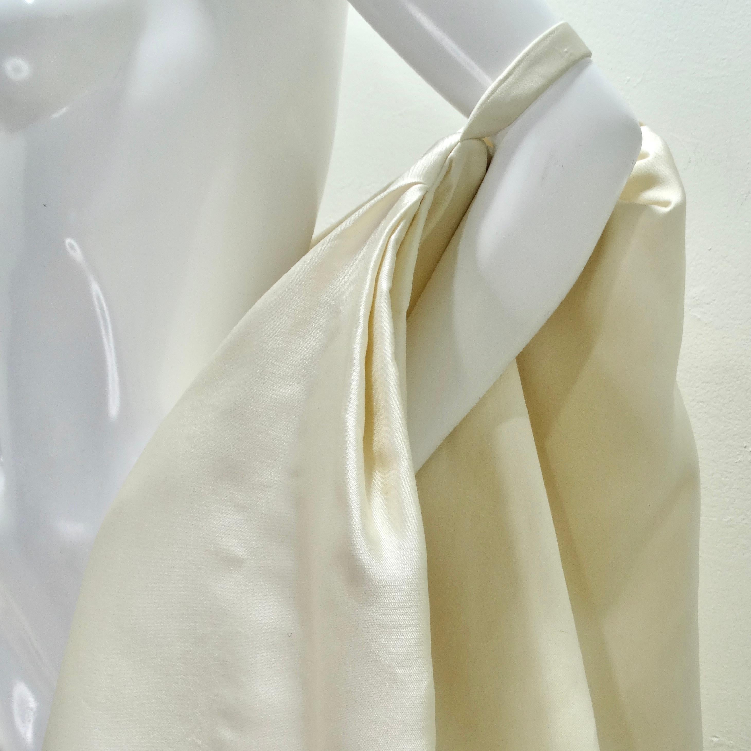 Dévoilez une touche de glamour vintage avec la cape en soie Donna Karan des années 1980 - une pièce de style unique et élégante qui capture l'essence de la sophistication intemporelle. Confectionnée dans une luxueuse soie ivoire, cette cape