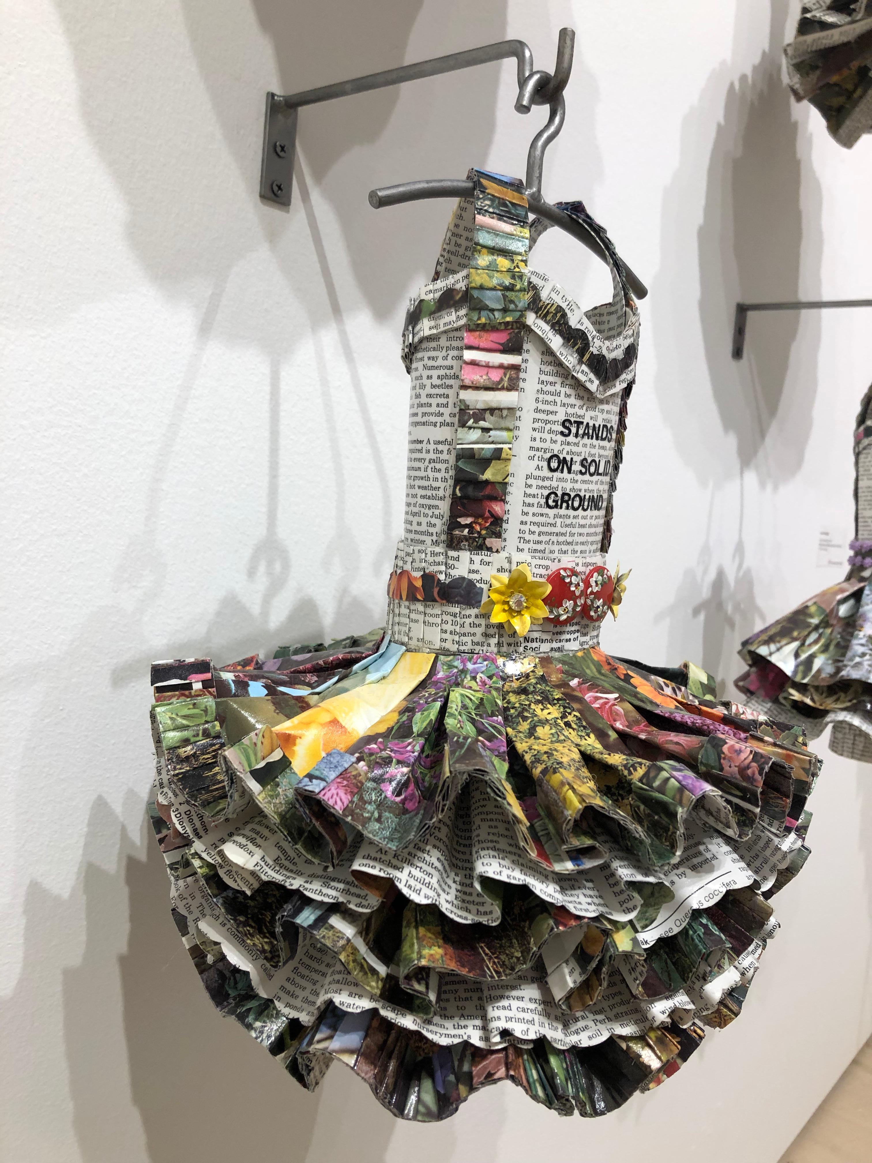 Dress sculpture made of vintage botanical books and trim. Paper features flowers and botanical text.
Stands on Solid Ground, from the Forces of Nature series
17 x 10.5 x 10 in.

New York-based artist Donna Rosenthal explores the effects of