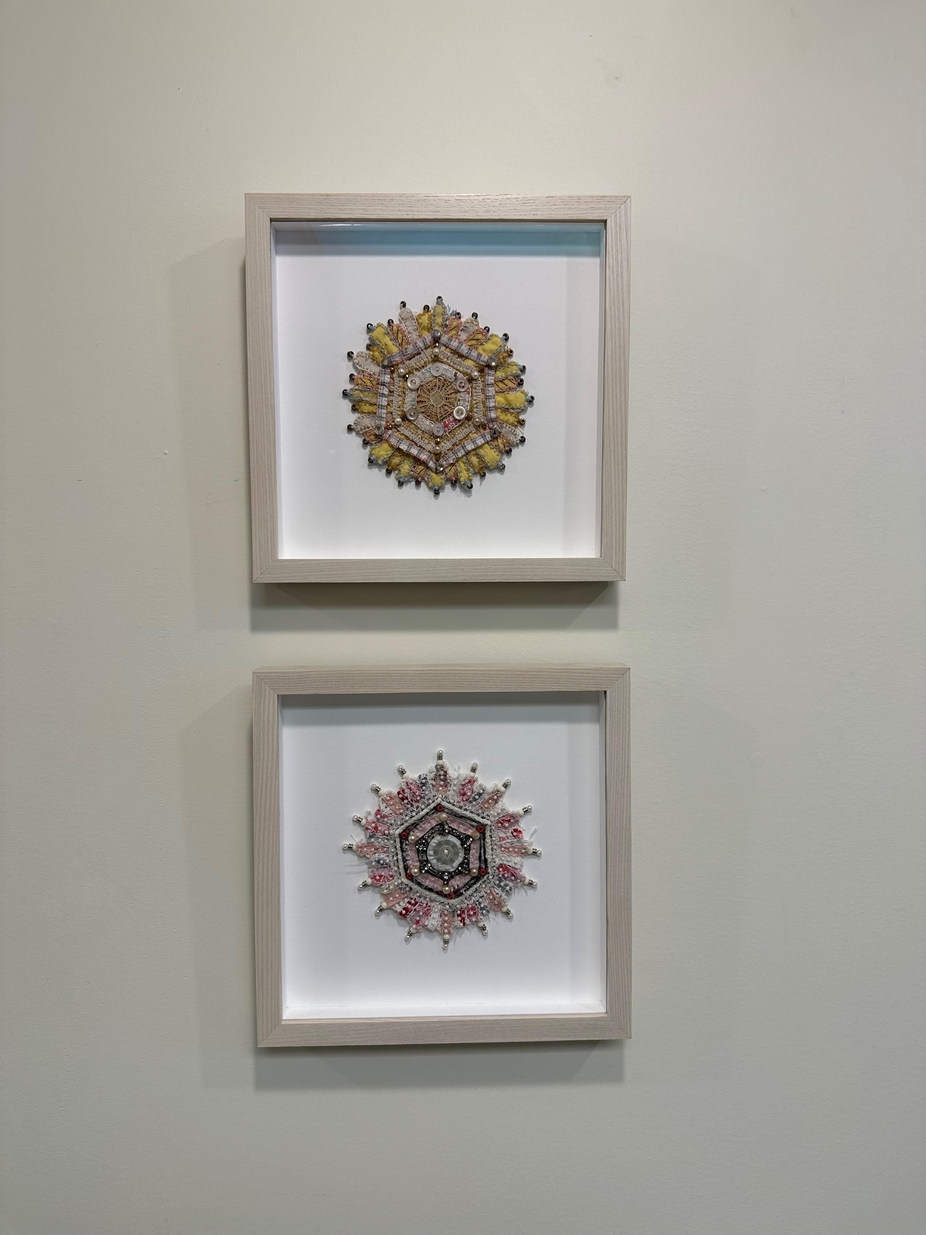 This contemporary textile mixed media mandala by Donna Sharrett contains guitar string ball-ends, clothing, needlework, jewelry, and thread, and is framed in a square 10 x 10 inch light natural wood float frame (5 x 5 inches unframed). 

Rhinestone