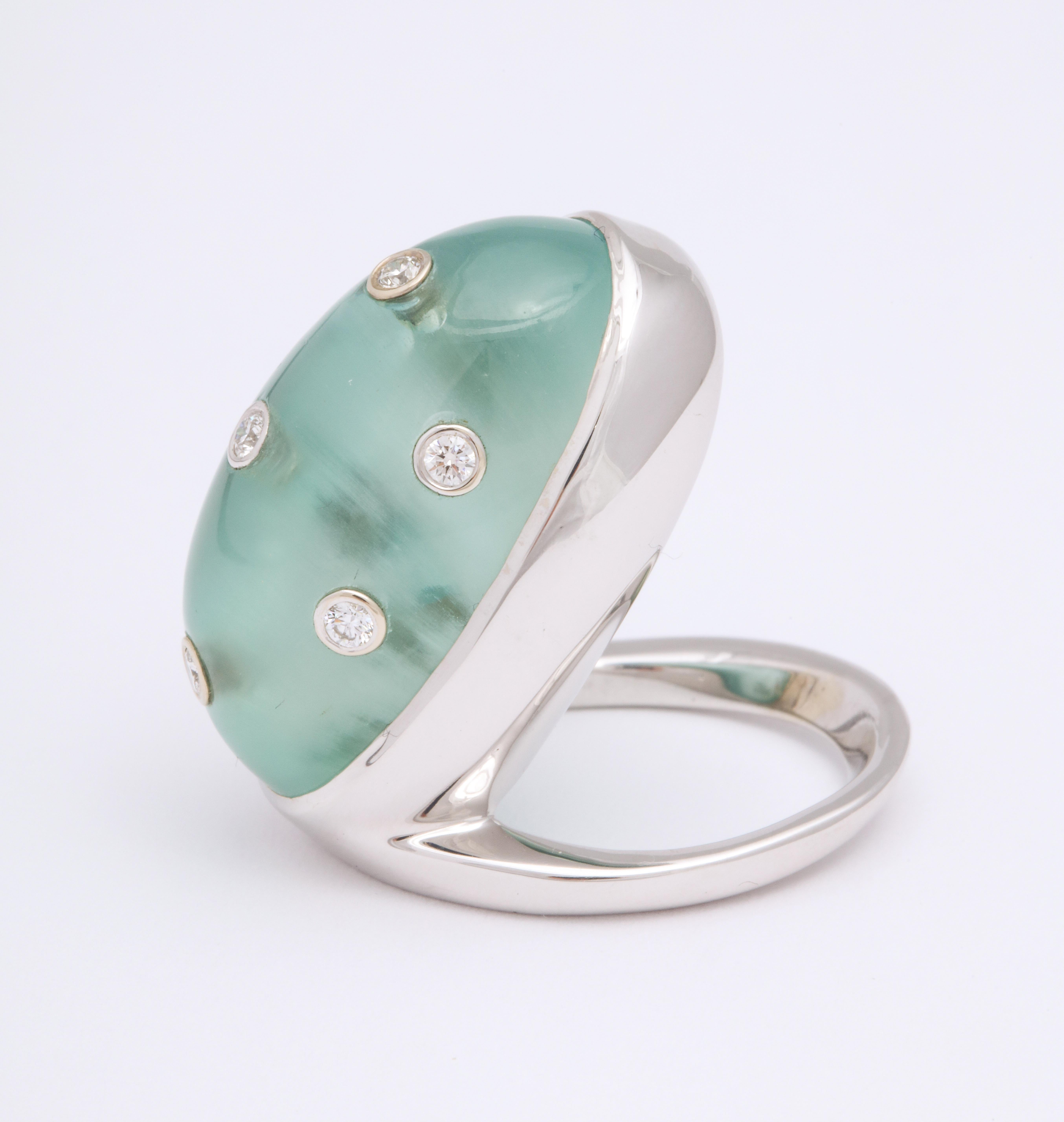 A modern ring featuring an unusually large aquamarine cabochon gemstone, weighing 42.32 carats. This asymmetrical bezel setting is a playful take on a medieval classic; a 21st century edition bezel-set solitaire made in 18K white gold. This