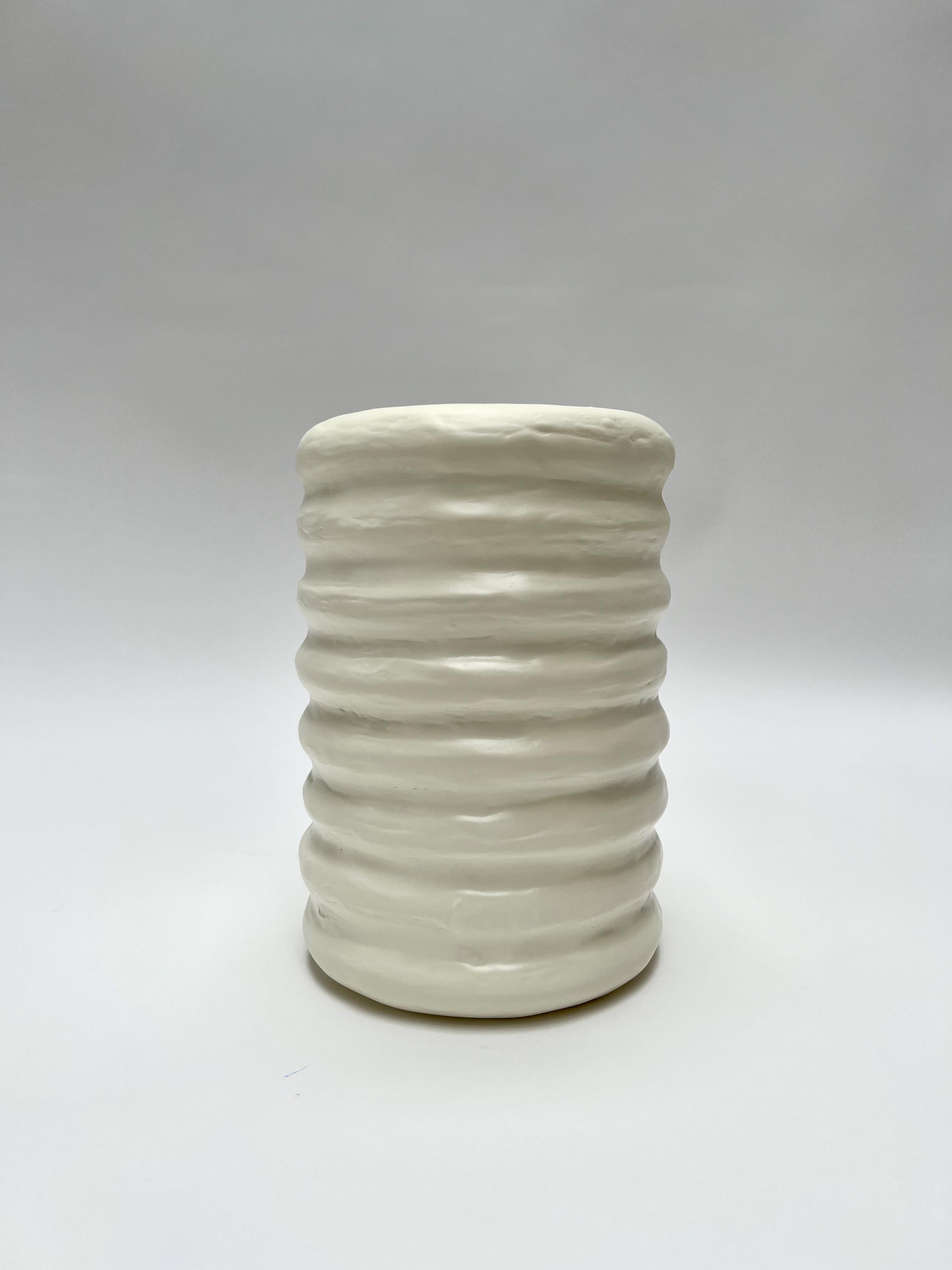 The Donut Vessel by Brent Warr is a sculptural study in rhythm and form. Composed of seamless, ring-like curves that flow into one another, its silhouette suggests a sense of movement and hand-formed fluidity. Finished in matte white fiberglass, the