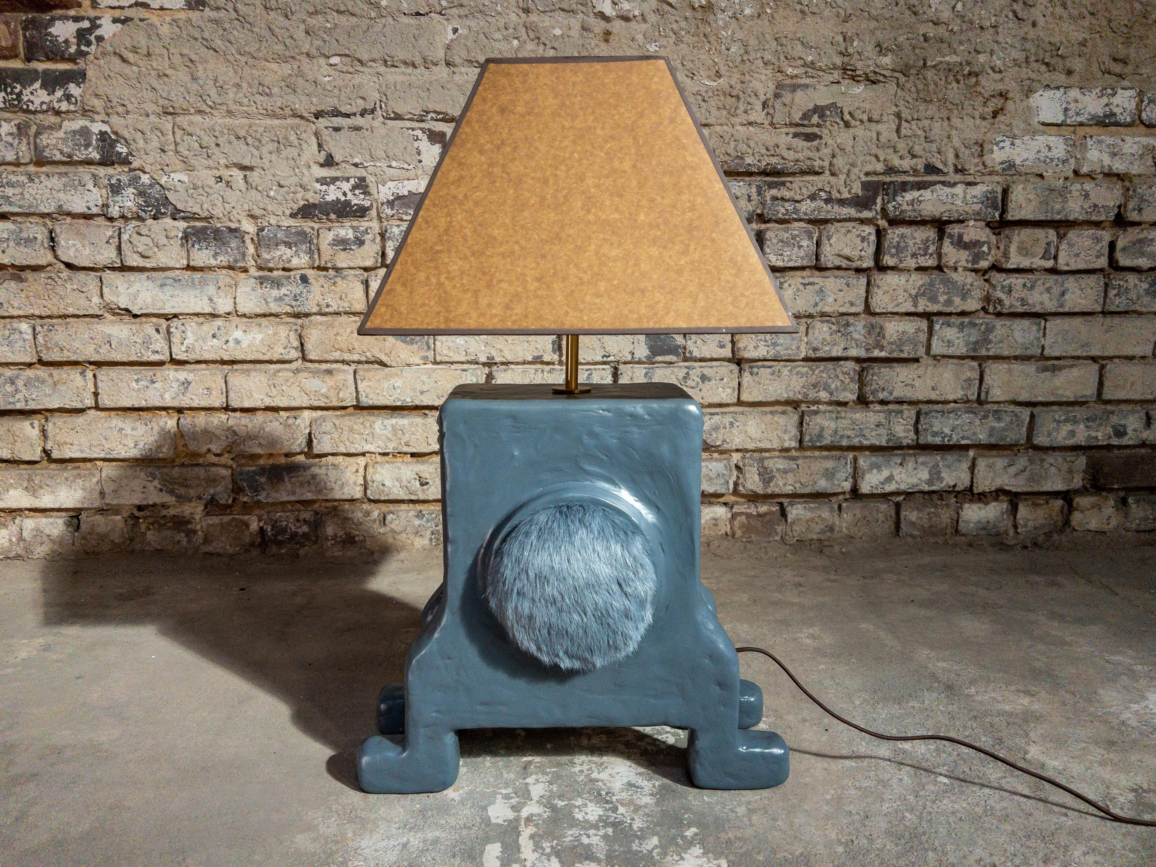 The Doodle Table Lamp by Brent Warr is a sculptural lighting piece that merges playfulness with refined craftsmanship. Its chunky, creature-like base—crafted from a gypsum, pulp, and epoxy blend over wood—is accented by a soft faux fur detail,