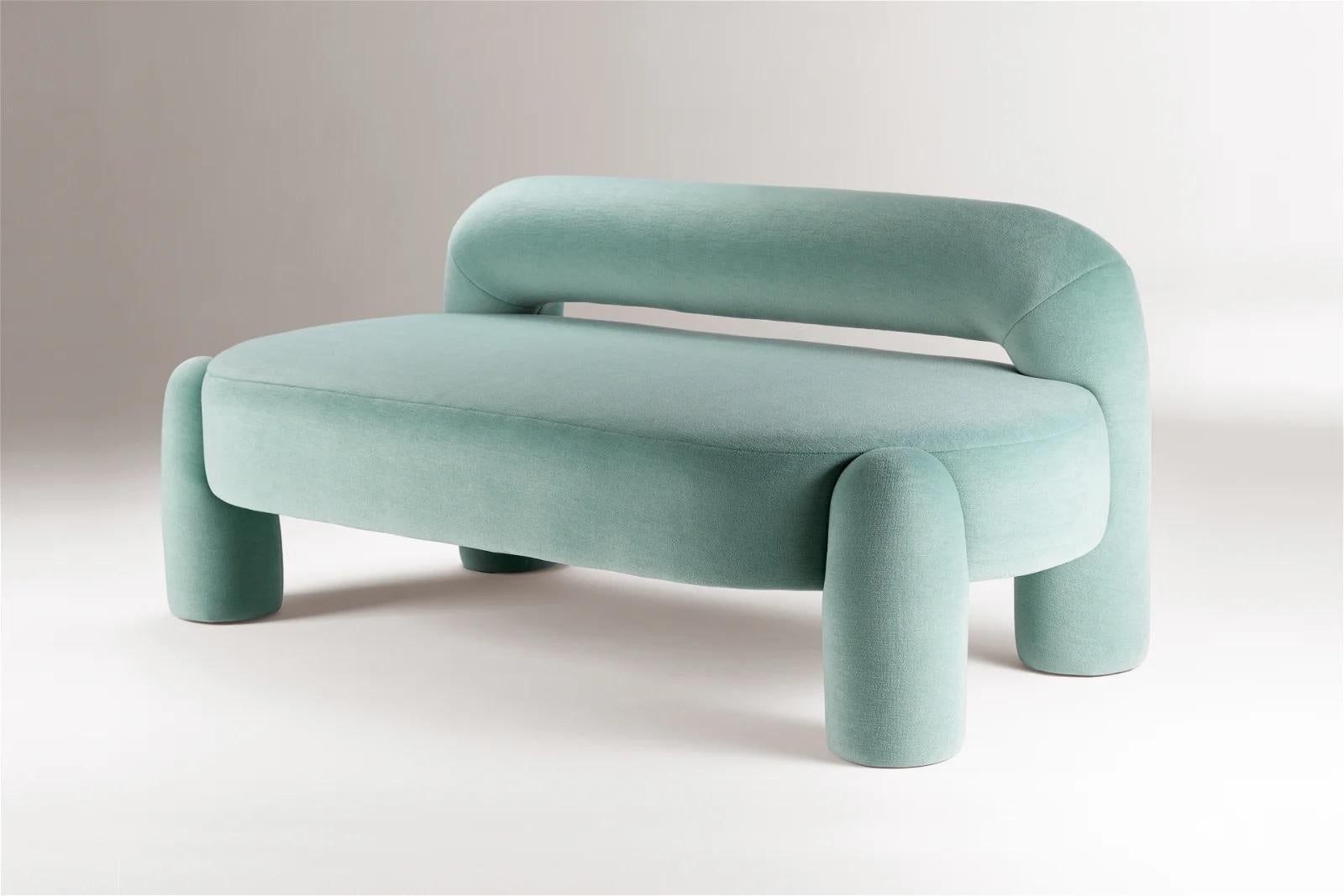 Cuando la geometría pura se une a las curvas suaves, surge algo escultural y sensual. Un fino diálogo entre patas sobredimensionadas y líneas limpias tiene lugar en esta pieza tapizada en terciopelo de mohair. Marlon es vanguardista y elegante al