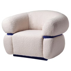 DOOQ Poltrona moderna organica in bouclé bianco sporco con dettagli in velluto blu Malibu