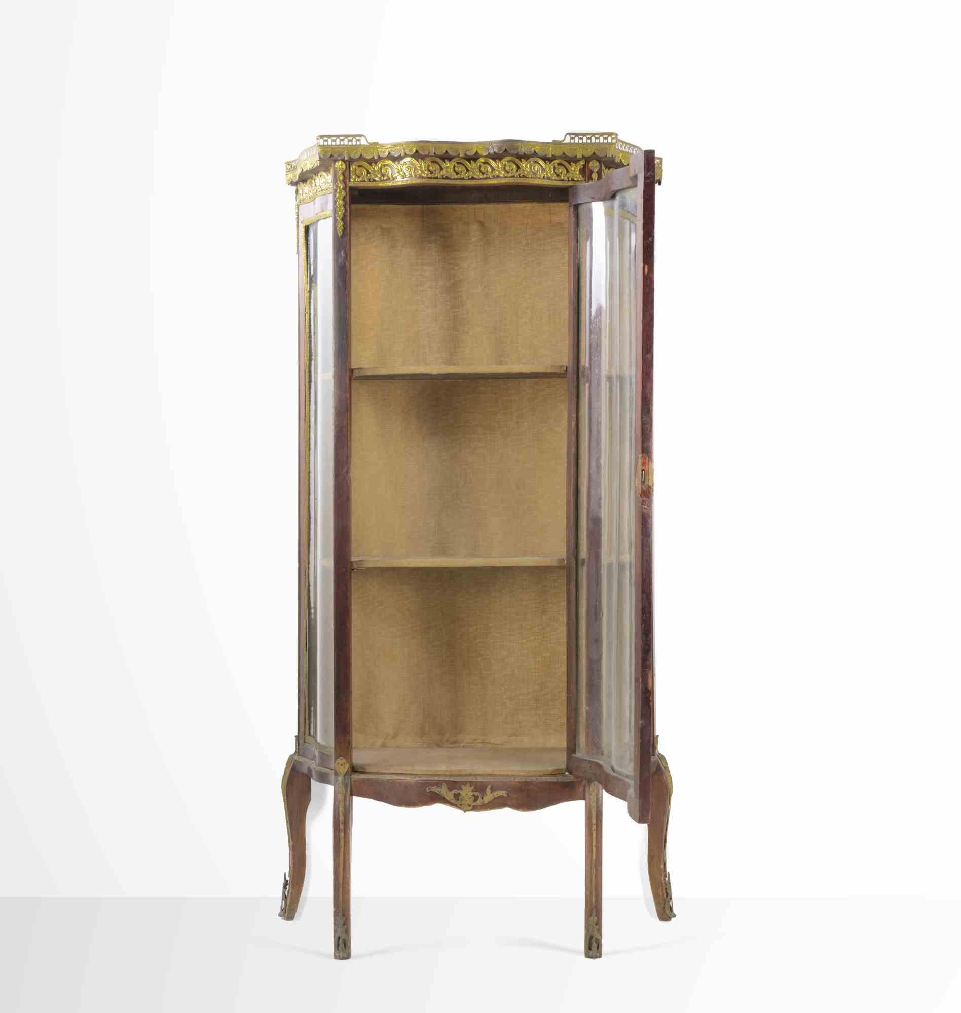 Vetrina francese in stile Napoleone III, forma semicircolare in mogano con 1 anta centrale, fregi e rifiniture in bronzo dorato e cesellato con motivi Impero, ripiano in marmo brecciato racchiuso da una ringhiera traforata, 4 gambe ricurve.

Buone
