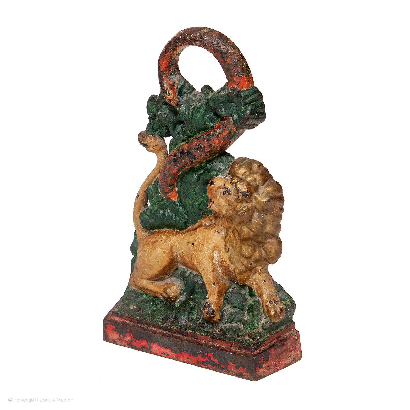 Victorian, cast iron, door stop with a lion & a serpent, retaining original green, red & gold paint, 11 ¼” high

Rare doorstop, representing protection against temptation.
The lion amongst foliage baring his teeth and looking up at the serpent