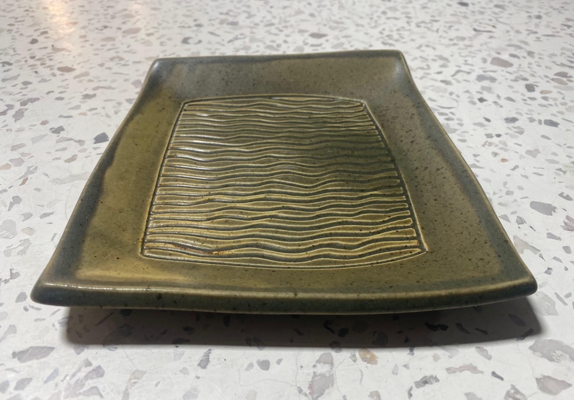 A beautifully designed and gorgeously earth-toned glazed plate by famed Mexican-American California studio art potter Dora De Larios. 

De Larios was born in Los Angeles to Mexican immigrant parents. She grew up in the artistic Silver Lake district