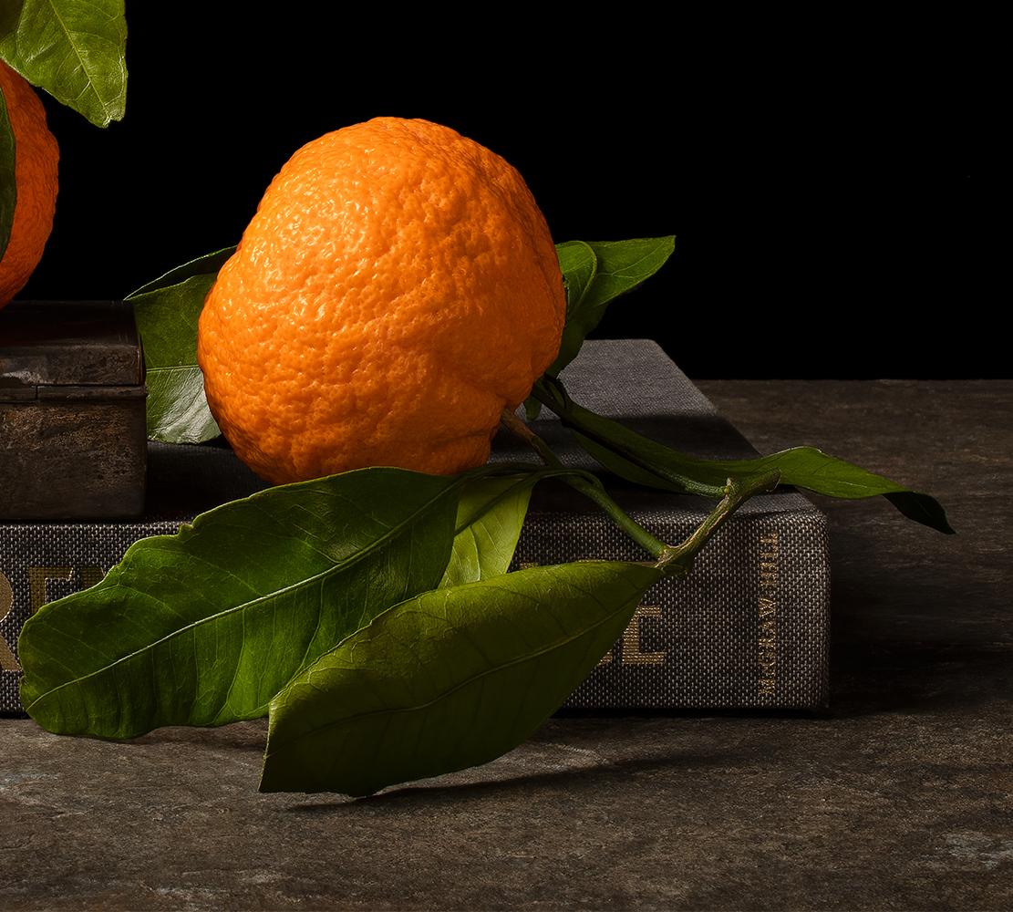 Mandarinas con libro. Aus der Serie Bodegones Stillleben-Farbfotografie (Schwarz), Still-Life Photograph, von Dora Franco