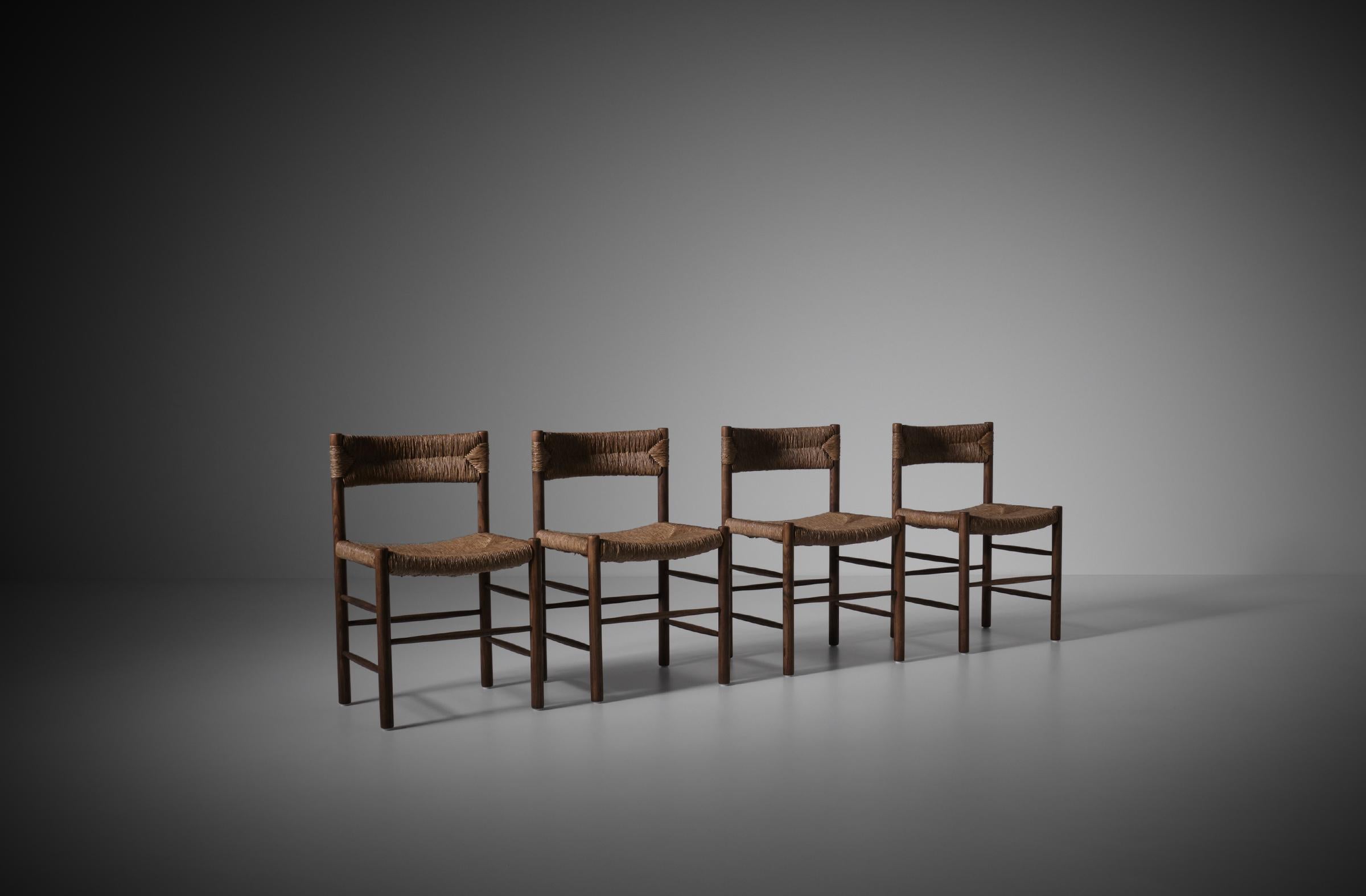 Set of four 'Dordogne' dining chairs by Robert Sentou, France 1950s. The chairs are made of solid dark stained Ash and have a rush seat and backrest in a beautiful woven pattern. The chairs provide a good comfort due to the wider seating part and