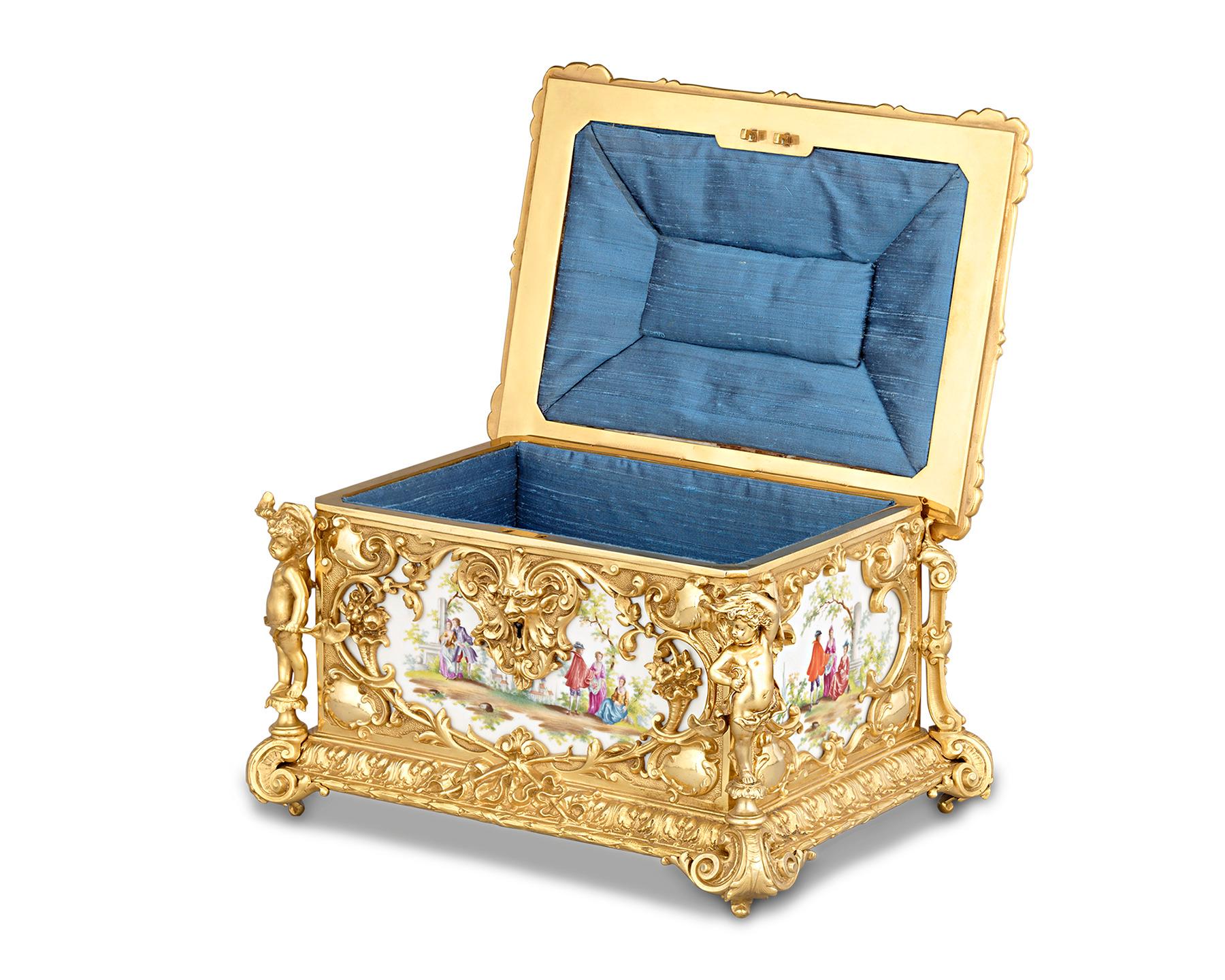 Meissen-styled European porcelain is framed by doré bronze of magnificent artistry in this delightful casket. The bronze is brilliantly detailed with rocaille flourishes and charming putti that frame beautifully hand-painted porcelain plaques on all