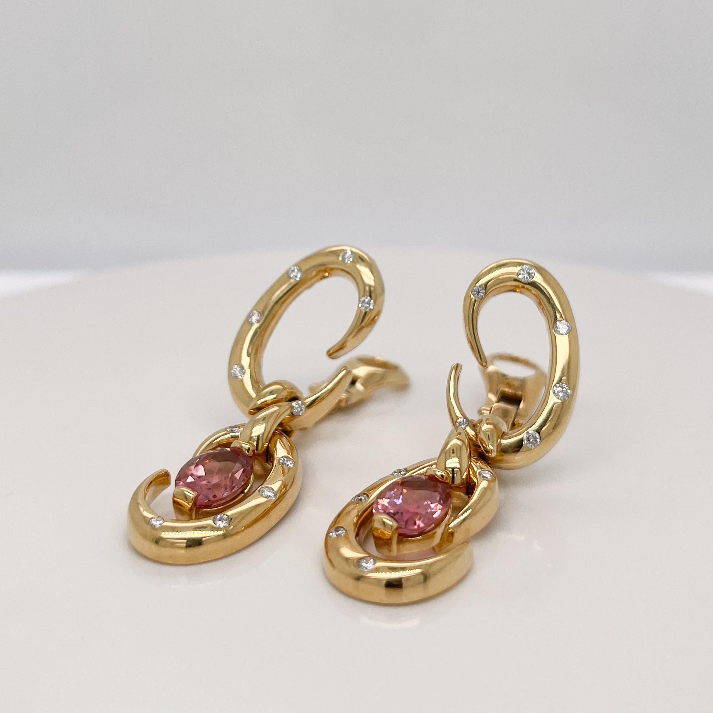 A very fine pair of stylish clip-on earrings.

By Dorfman. 

With faceted oval purple (pink) tourmaline gemstone prong set in 18k gold and with scattered, flush set  round white diamonds throughout.

A simply beautiful pair of clip earrings by