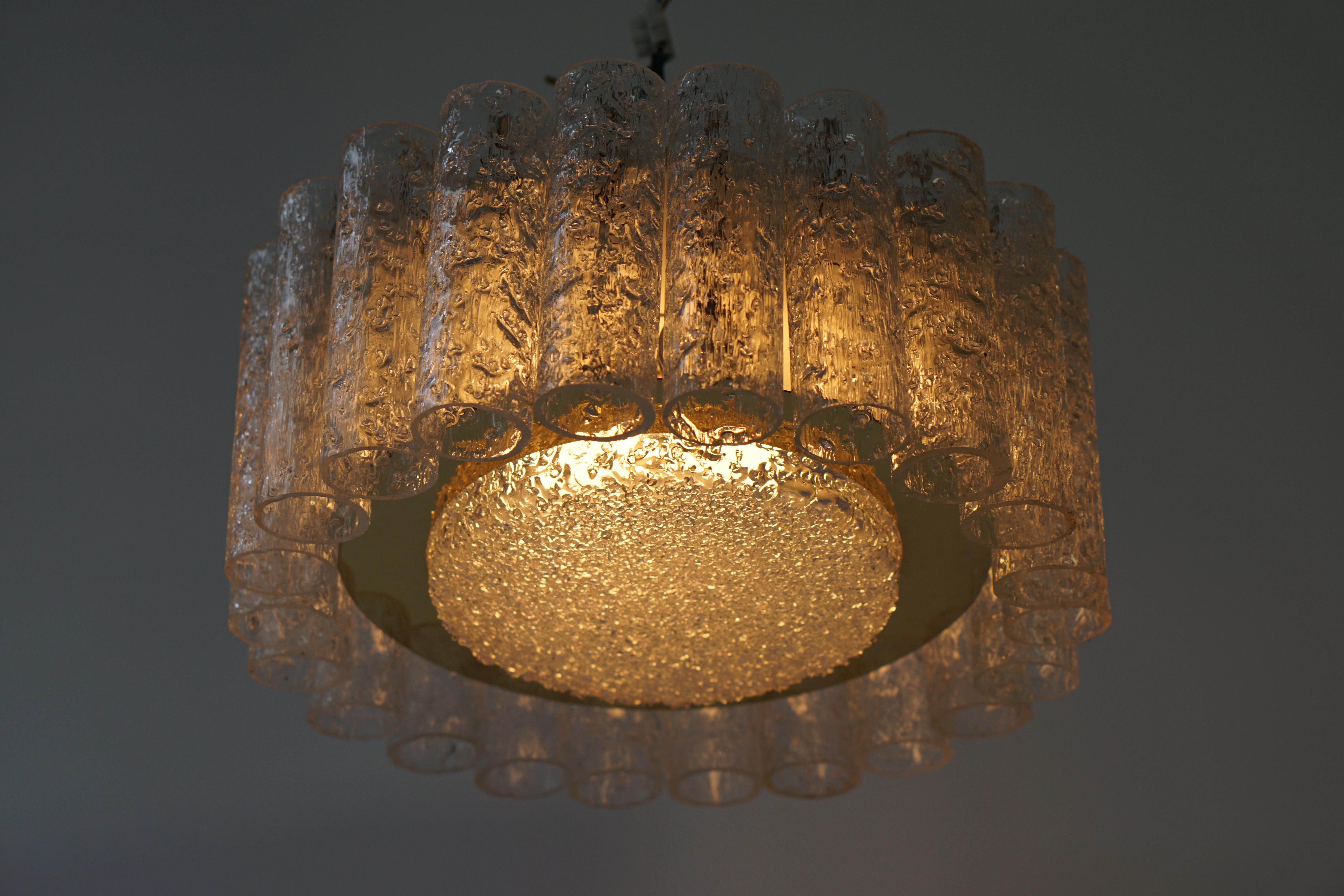 The textured glass chandelier features 22 pieces of textured glass tubes and the chandelier was designed and manufactured by Doria Leuchten, Germany, 1960s.
A beautiful chandelier from the Mid-Century Modern era! The vintage condition is very