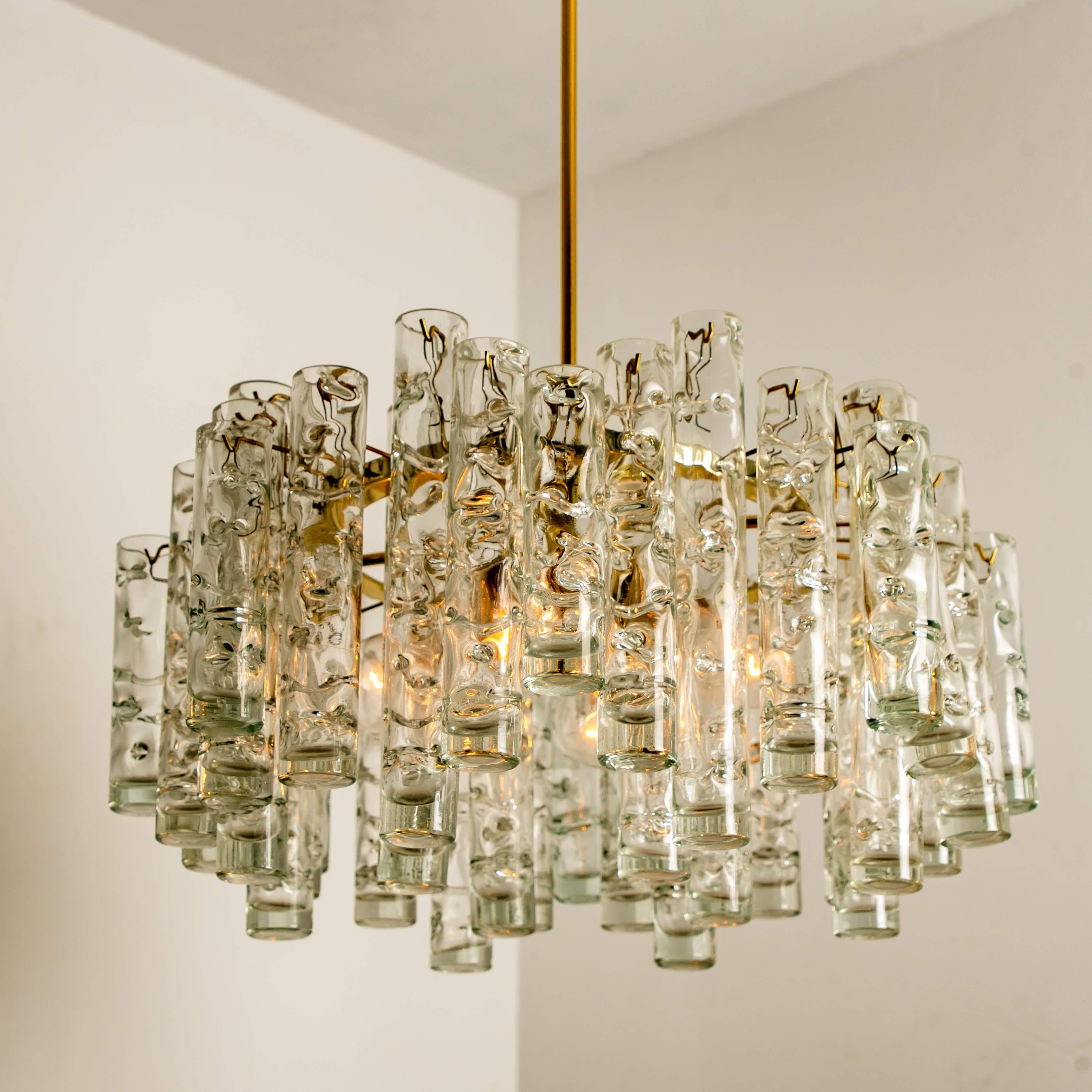 Amazing Doria light fixture. Beautiful craftmanship from the midcentury. The light fixture features a frame with brass details and large hand blown glass tubes. The glass has a nice pattern in it, what gives a nice diffuse light effect and a nice