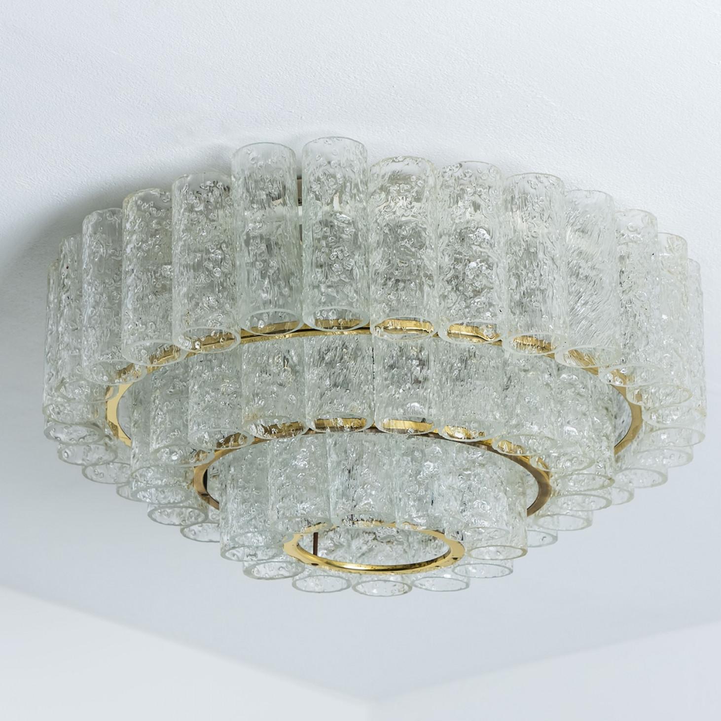 Mid-century modern chandelier produced by Doria Leuchten in Germany in the 1960s.

The lamp features a brass frame with three rings and hooks. Hanging from the hooks are the loose Murano glass tubes.

The chandelier has six E14 sockets facing
