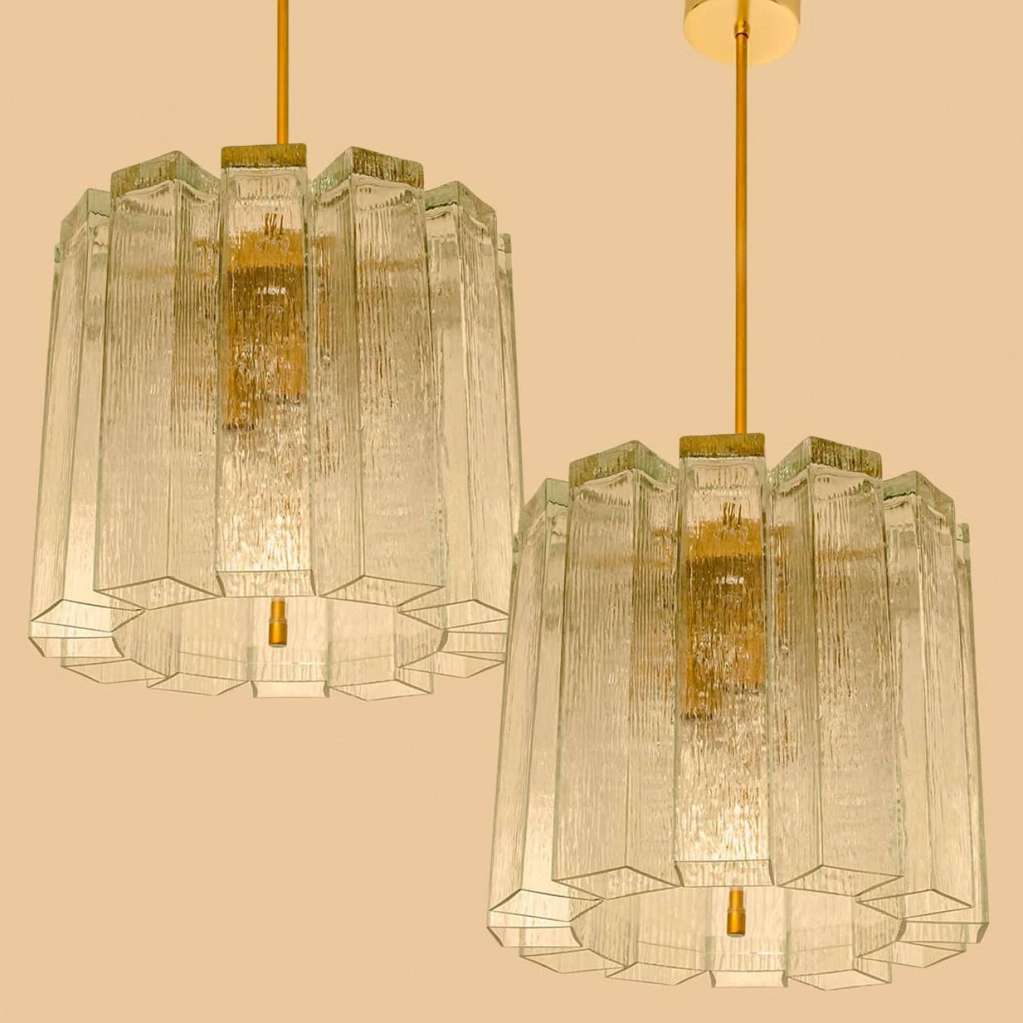 Pendente moderno di metà secolo prodotto da Doria Leuchten Germany negli anni Sessanta. La lampada presenta una struttura in ottone da cui pendono 12 tubi in vetro di Murano.

Il lampadario è dotato di otto prese E14 rivolte lateralmente per una