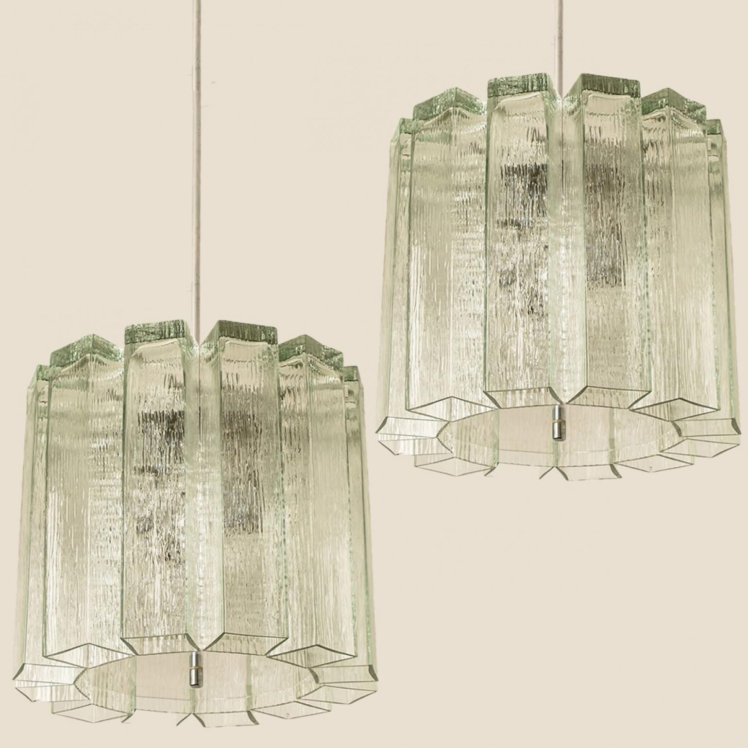 Pendente moderno di metà secolo prodotto da Doria Leuchten Germany negli anni Sessanta. La lampada presenta una struttura cromata da cui pendono 12 tubi in vetro di Murano.

Il lampadario è dotato di otto prese E14 rivolte lateralmente per una