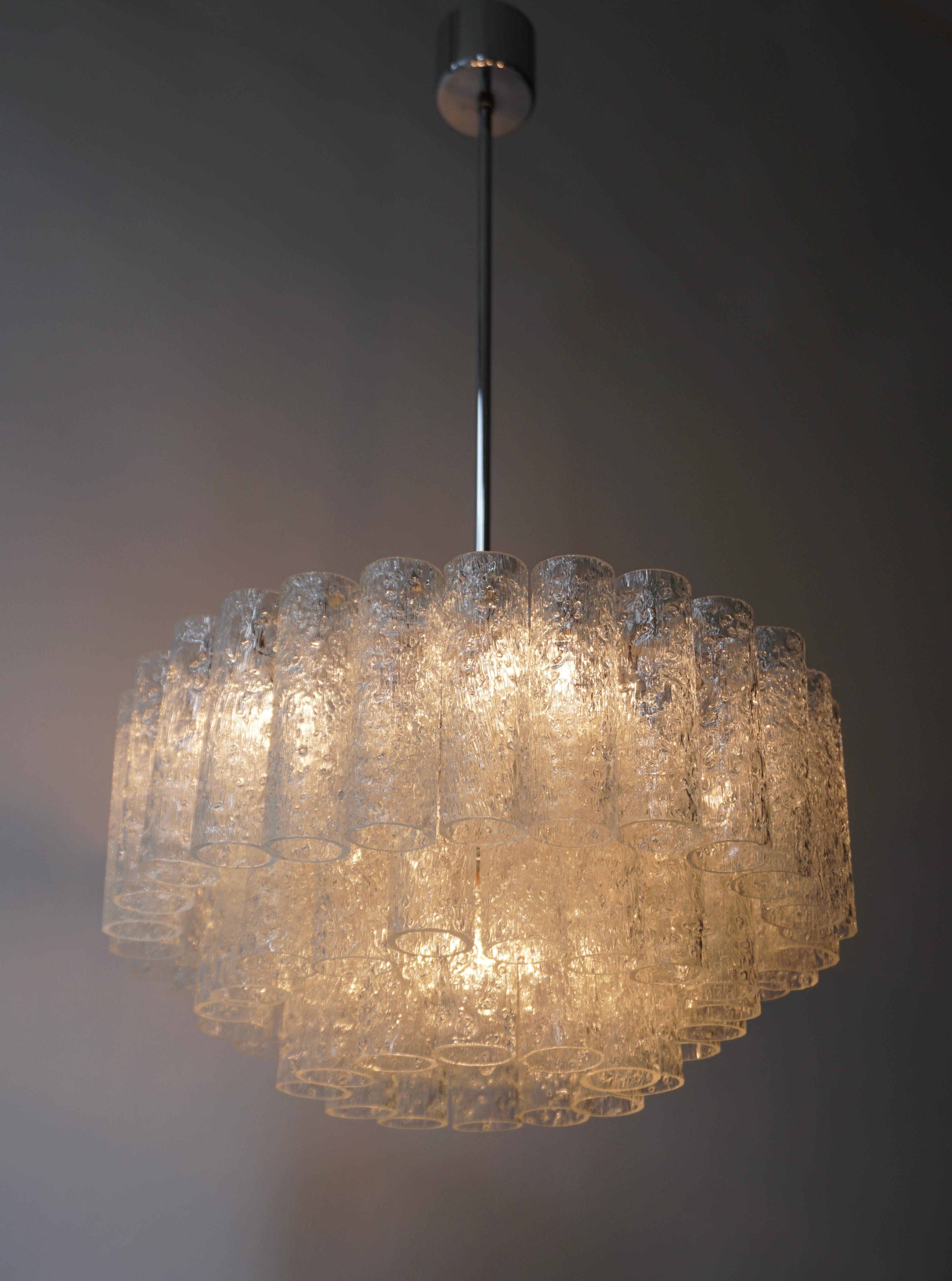 1960s chandelier by Doria, Germany. Three tiers of 60 textured glass tubes on brass and white frame. 

The light requires four single E14 and one E27 screw fit lightbulbs (60Watt max.) LED compatible.

Dimensions: 
Diameter 42 cm.
Height